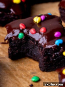 Decadent Cosmic Brownies 11 A perfectly baked, fudgy homemade Cosmic Brownie with a bite taken out, showing its rich texture and colorful candy topping.