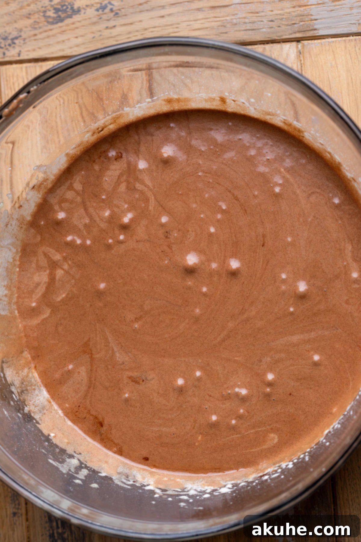 Decadent Cosmic Brownies 4 Bowl containing wet brownie ingredients: melted butter, oil, vanilla, and chocolate mixed with the egg-sugar mixture.