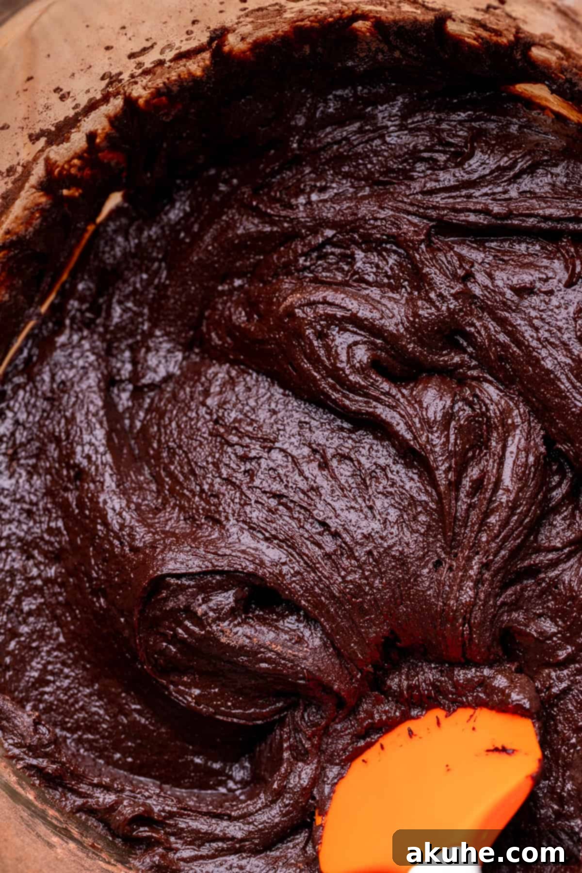 Decadent Cosmic Brownies 5 Close-up of brownie batter in a glass mixing bowl, showing its thick and glossy consistency before baking.