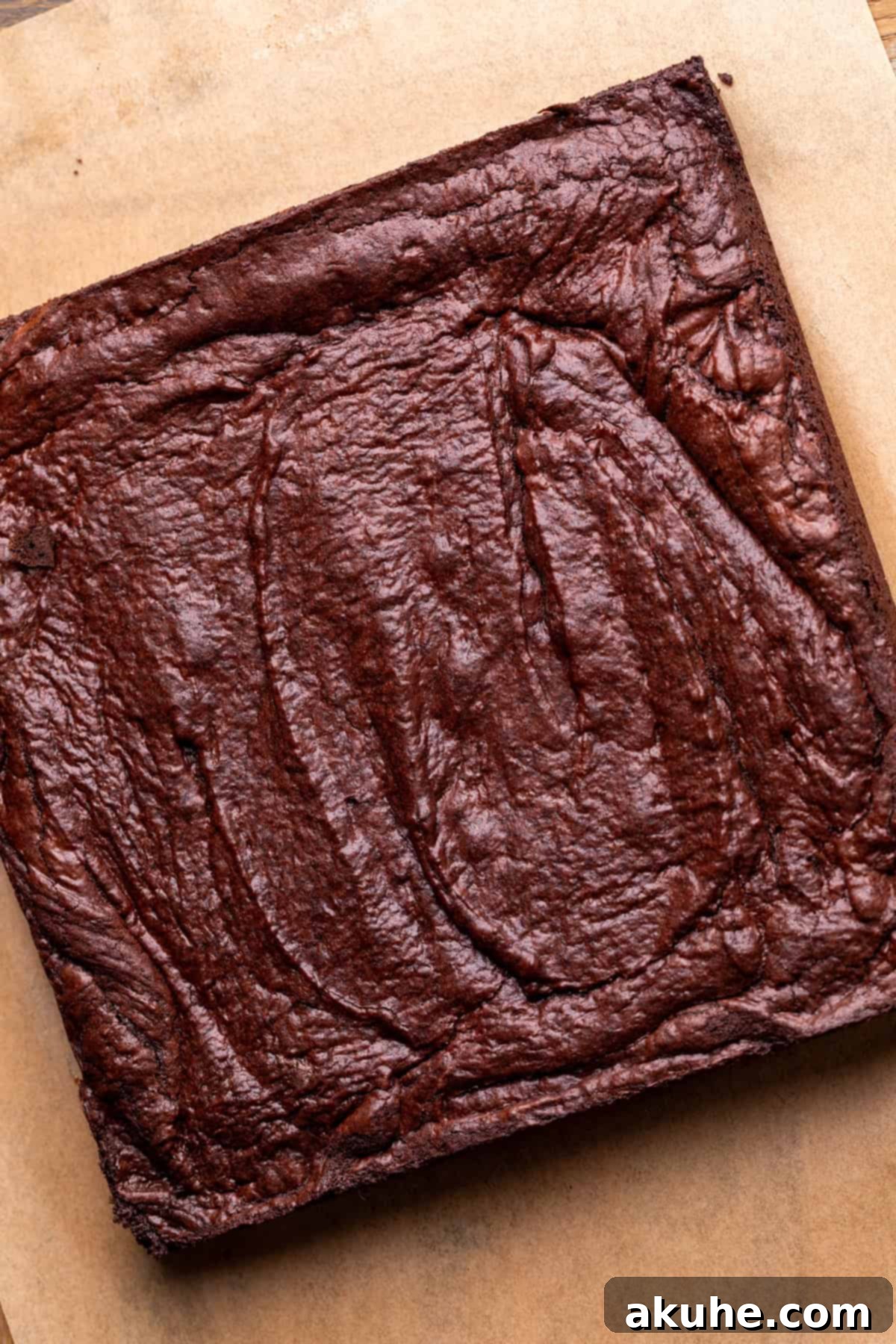 Decadent Cosmic Brownies 7 Freshly baked brownies, cooled and still in the parchment-lined pan, showing a slightly crinkled top crust.