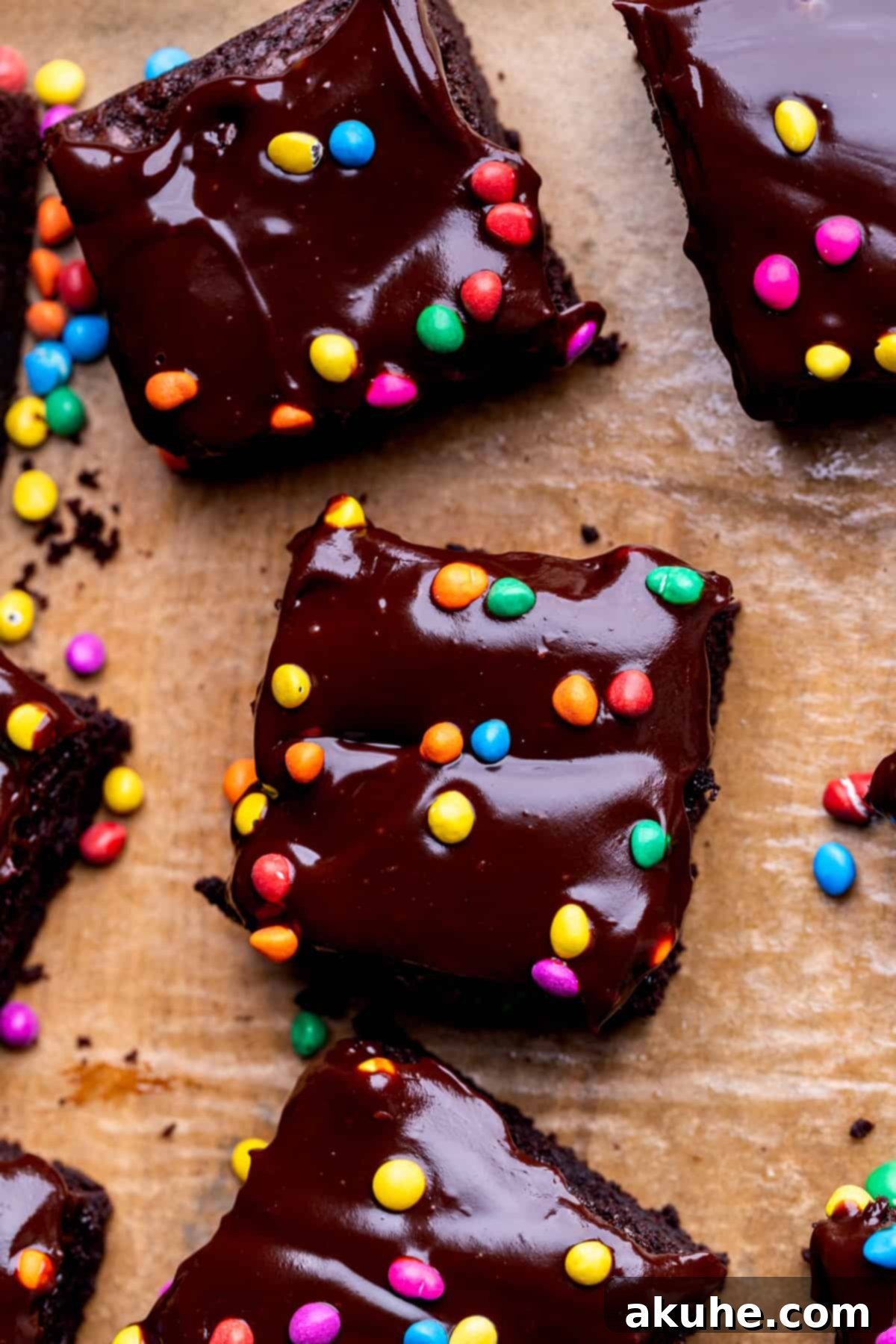 Decadent Cosmic Brownies 8 Overhead shot of freshly baked Cosmic Brownies in a pan, covered with glossy chocolate ganache and vibrant rainbow candy pieces.