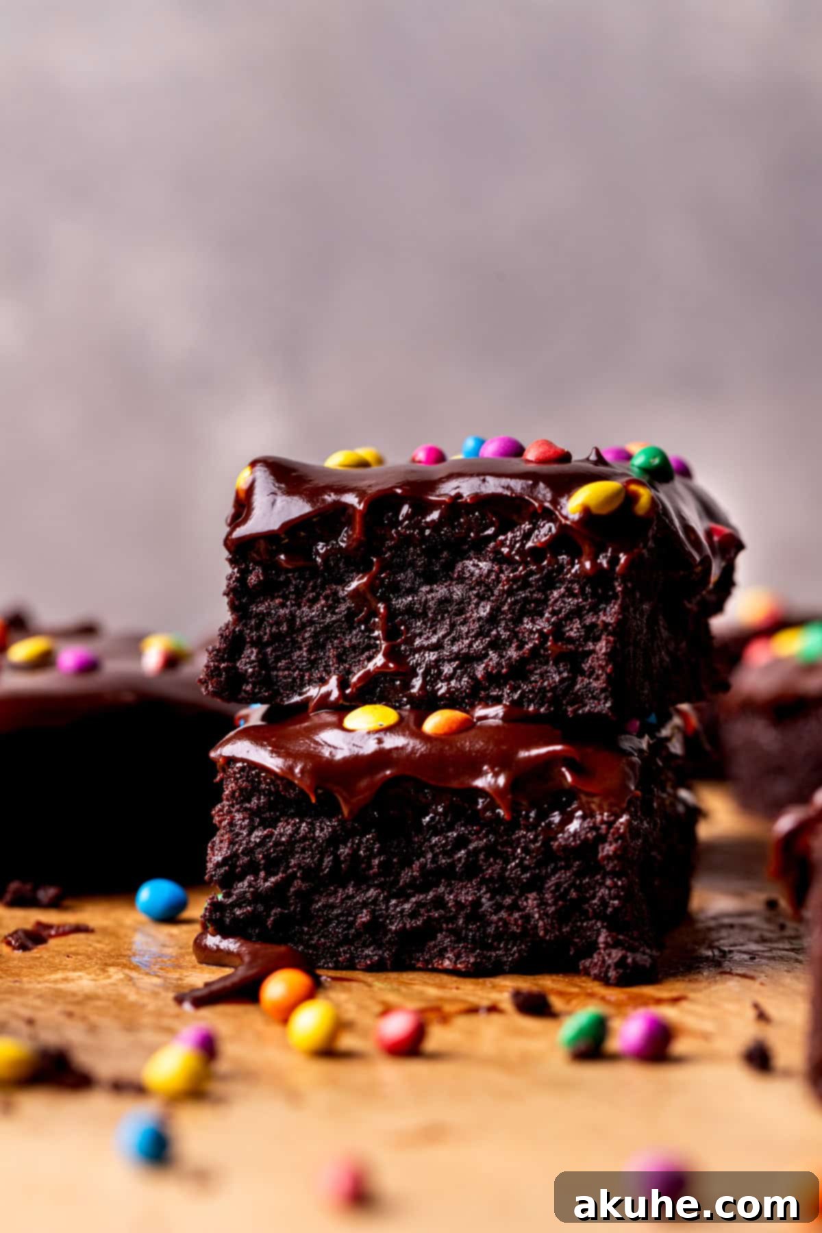 Decadent Cosmic Brownies 10 A stack of two perfectly fudgy Cosmic Brownies, showcasing their thick layers of brownie, ganache, and rainbow candies.