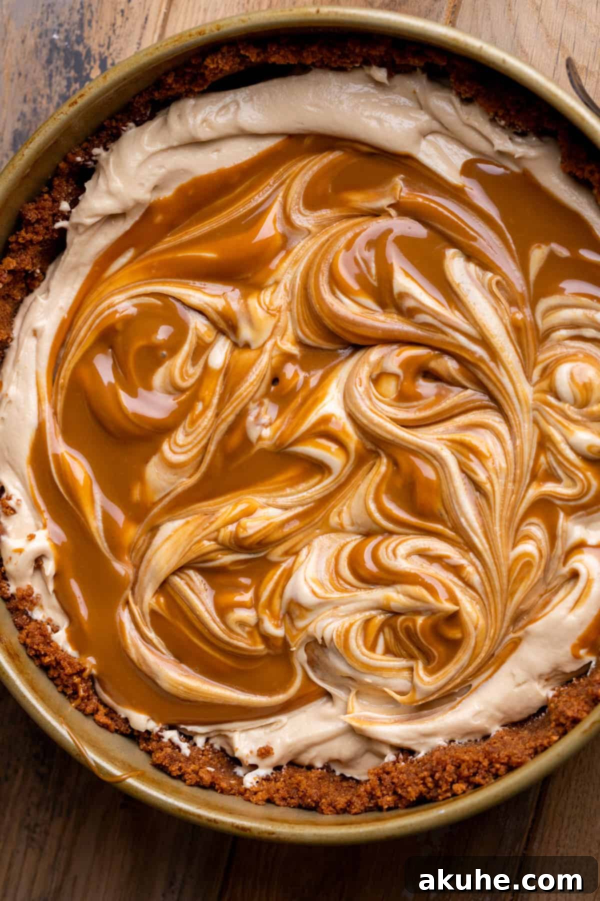 Decadent No-Bake Biscoff Cheesecake 7 Biscoff cheesecake in a pan with melted biscoff on top.