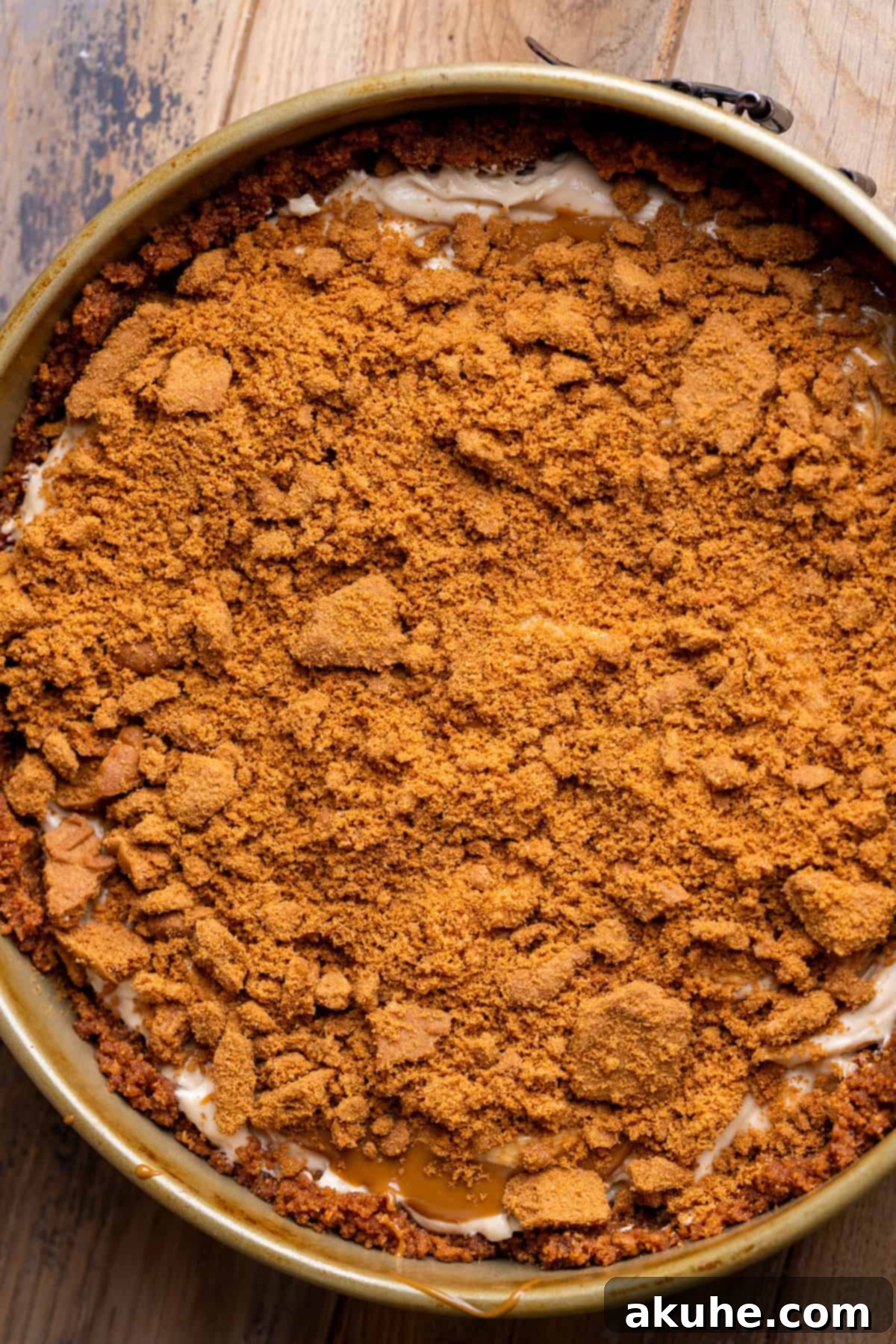 Decadent No-Bake Biscoff Cheesecake 8 Cookie crumbs on top of cheesecake batter.