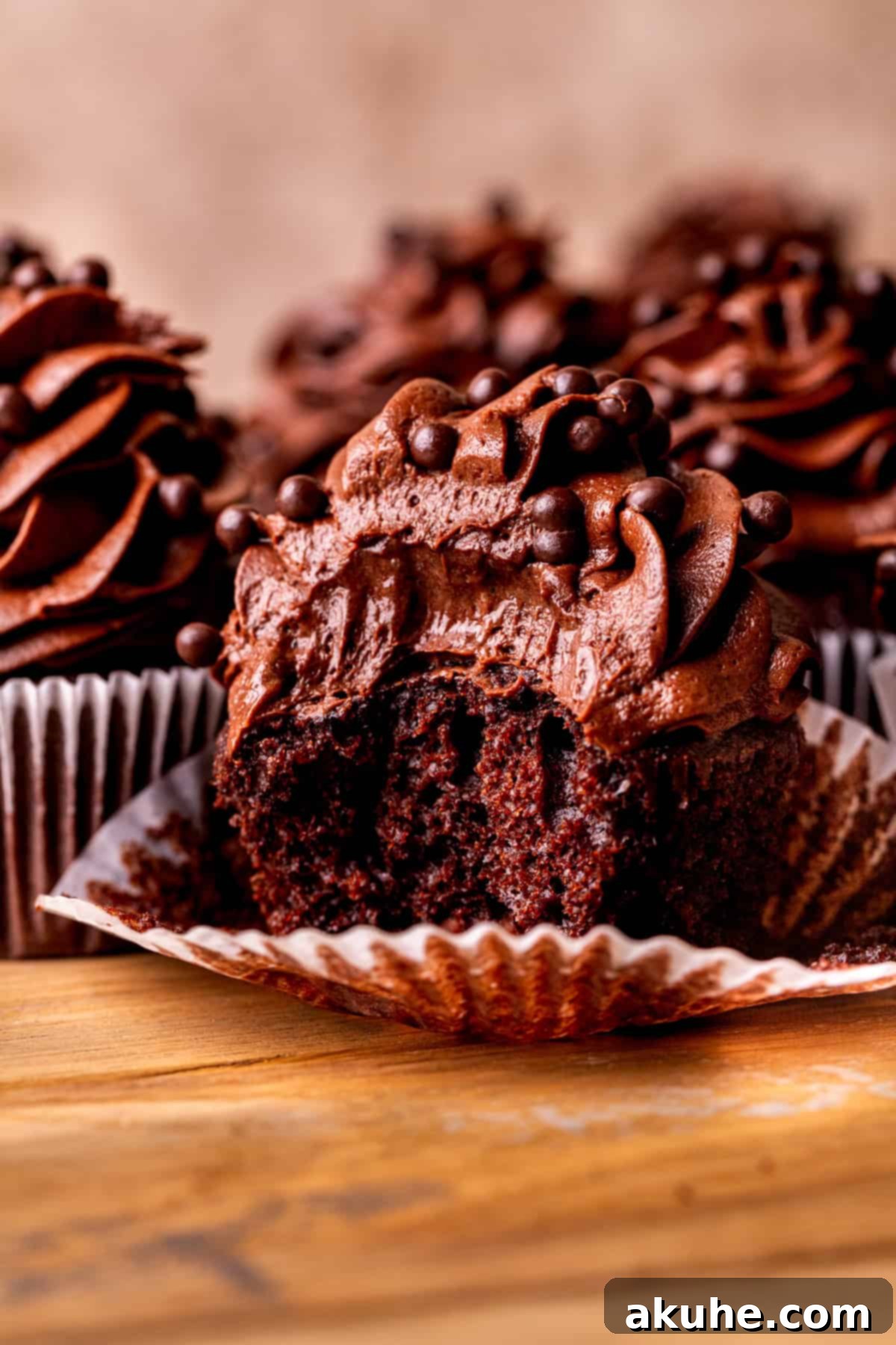 Decadent Chocolate Delights 2 One chocolate cupcake with a bite missing, showcasing its moist texture and creamy frosting.