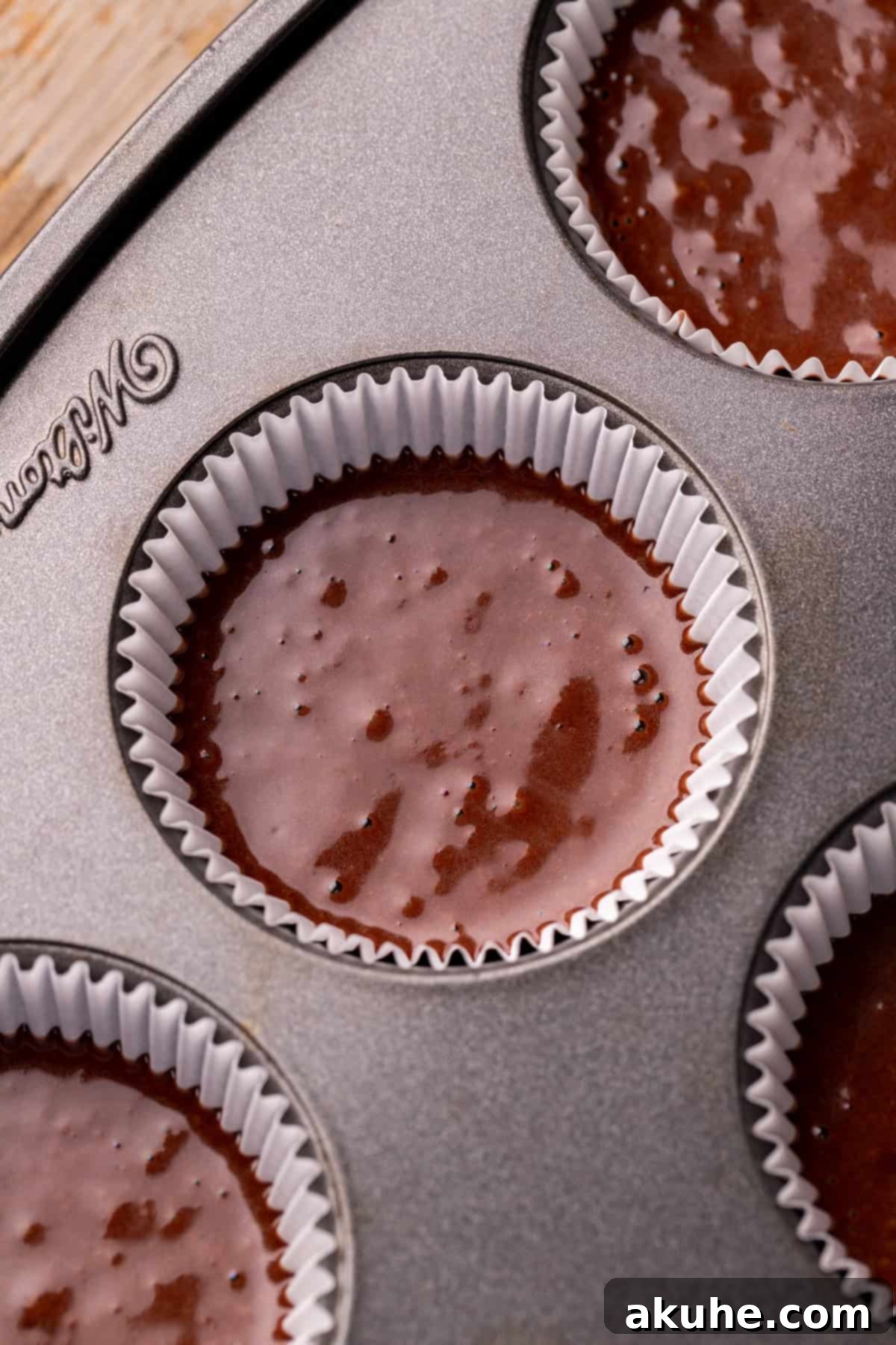 Decadent Chocolate Delights 6 Cupcake batter neatly scooped into a cupcake pan with liners.