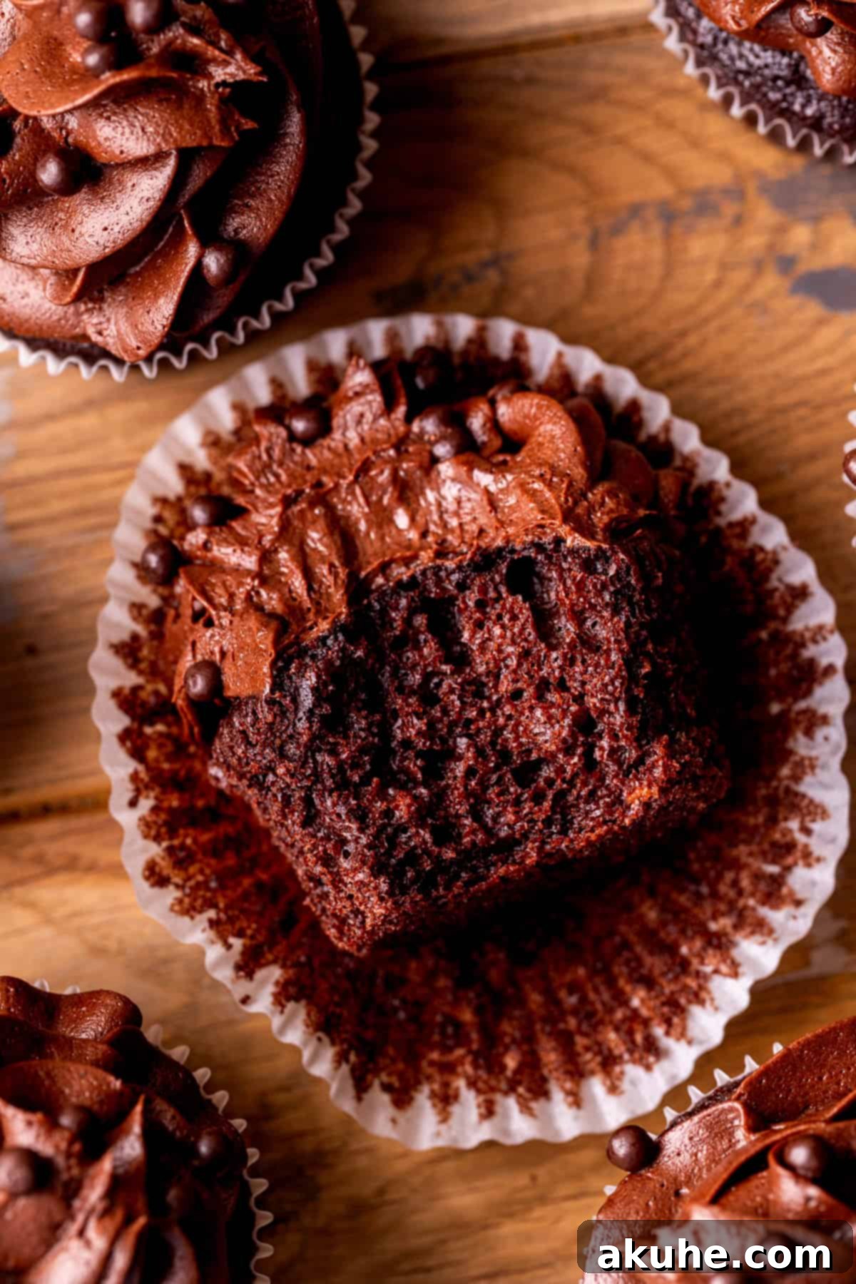 Decadent Chocolate Delights 10 One chocolate cupcake with a bite missing, showcasing its moist texture and creamy frosting from a top-down view.