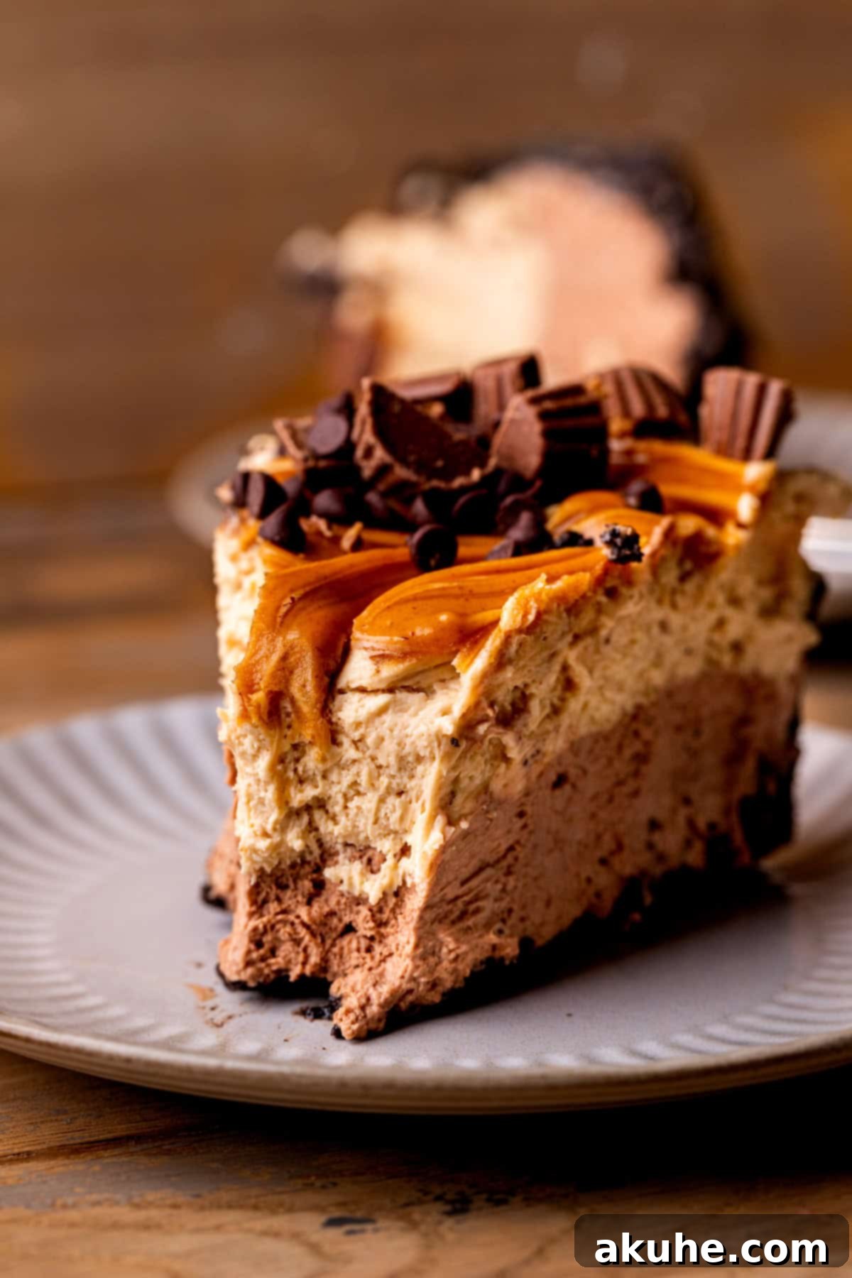 A single perfect slice of chocolate peanut butter pie on a white plate, showcasing its layers beautifully.