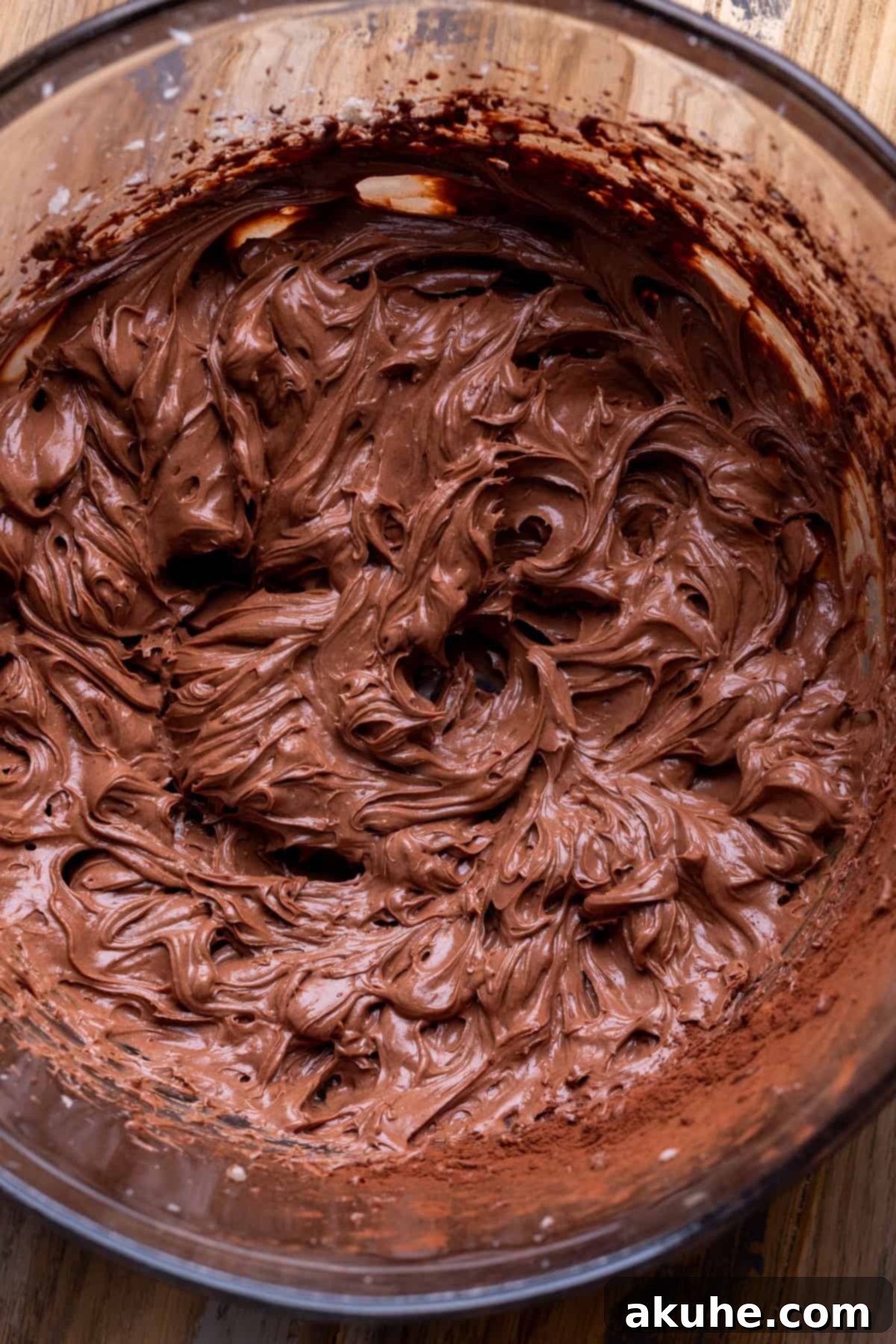 Smooth and rich chocolate filling in a clear glass bowl, showcasing its readiness.