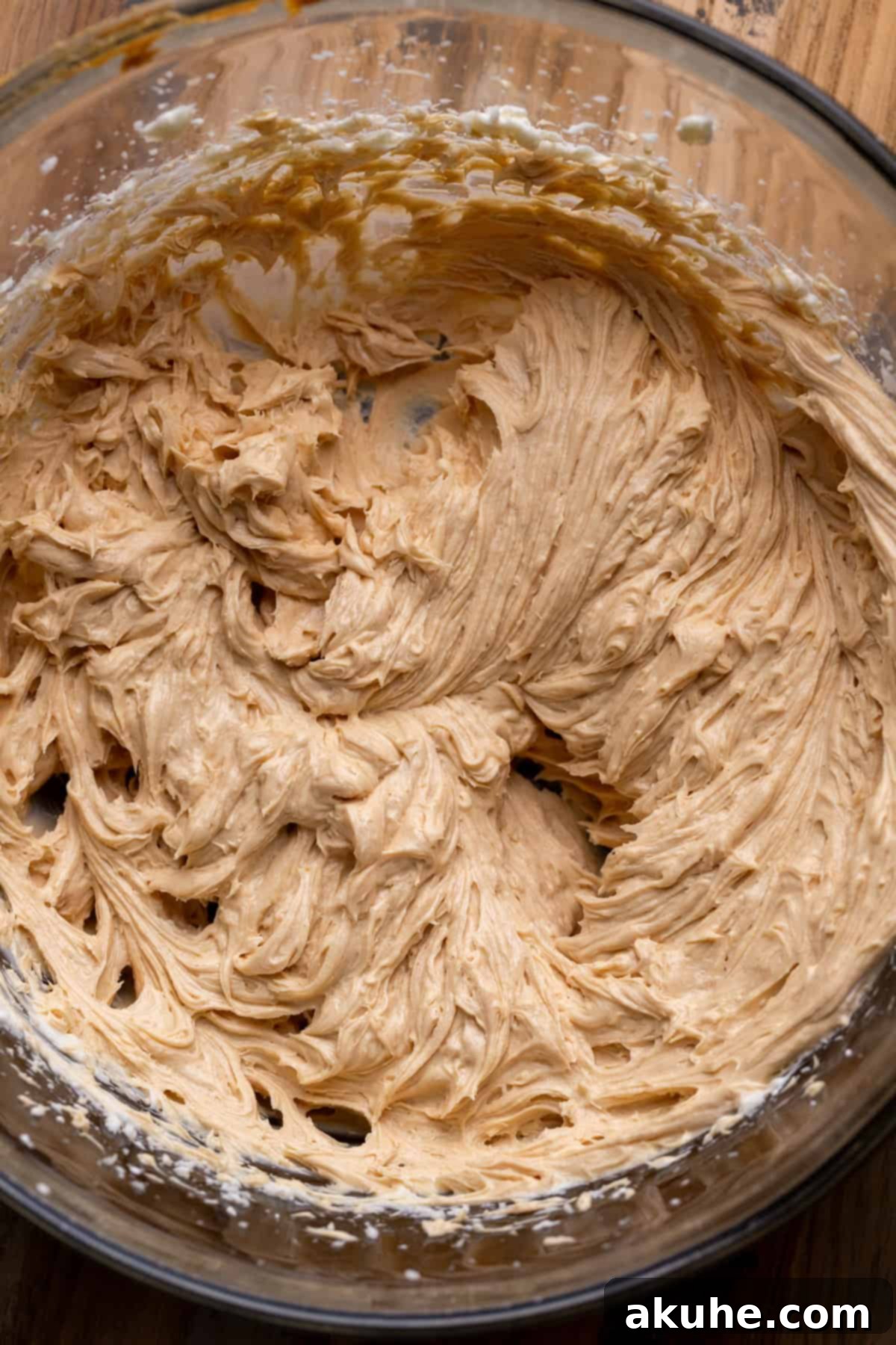 Smooth and creamy peanut butter batter in a clear glass bowl, ready for the next step.