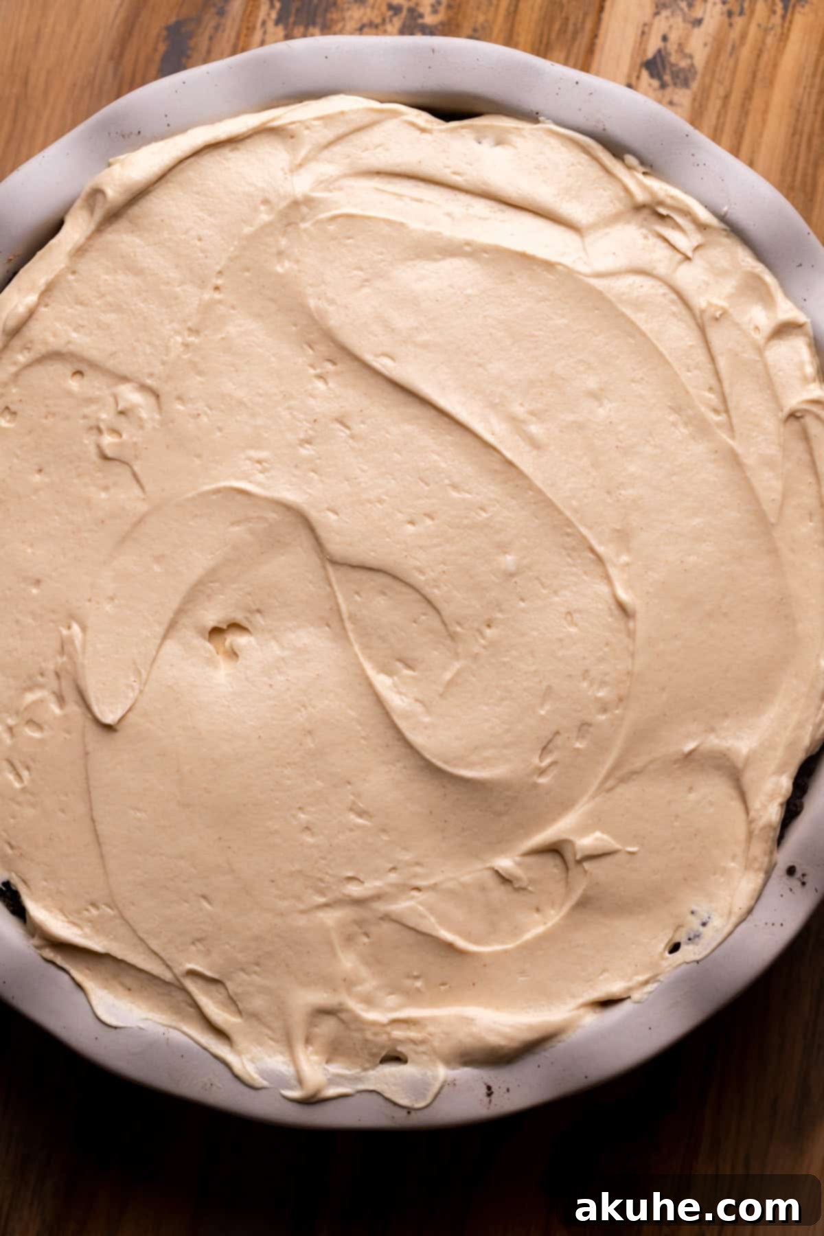 Second layer of peanut butter pie batter spread over the chocolate layer in a pie pan.