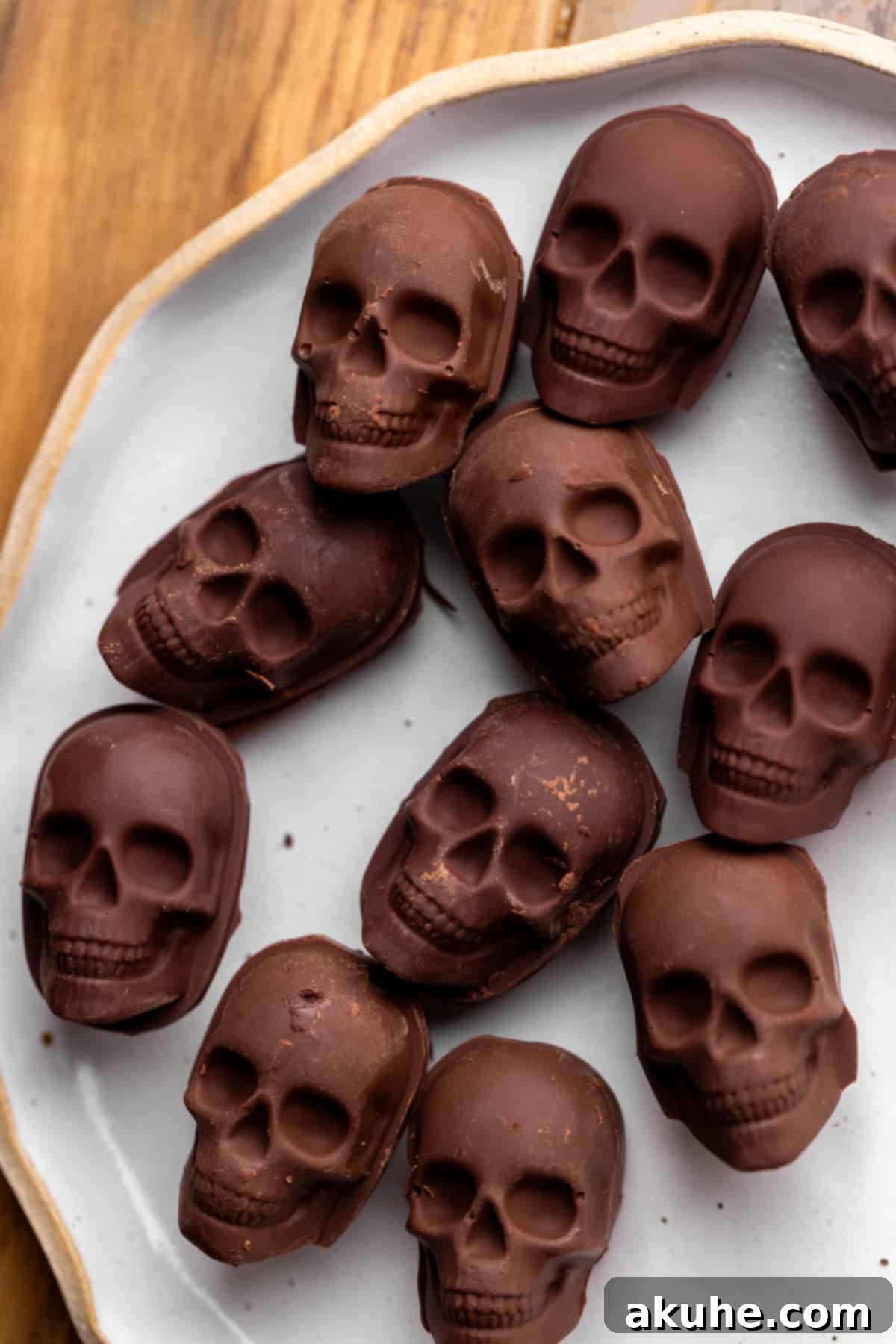 Bewitching Halloween Chocolate Cake 8 Intricate chocolate skulls arranged on a small plate, ready to be used as decoration for the Halloween cake.
