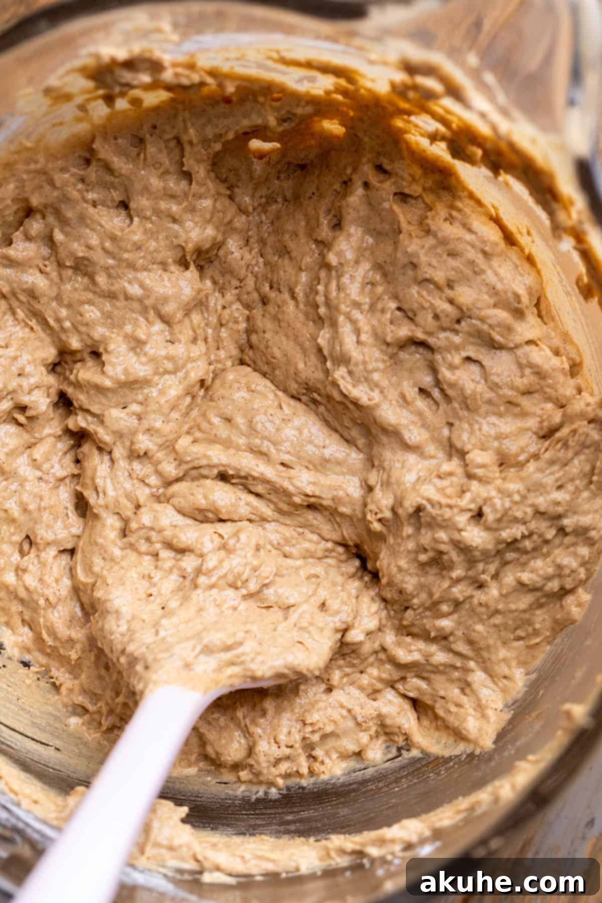 Cinnamon cake batter in a glass bowl, ready for baking.