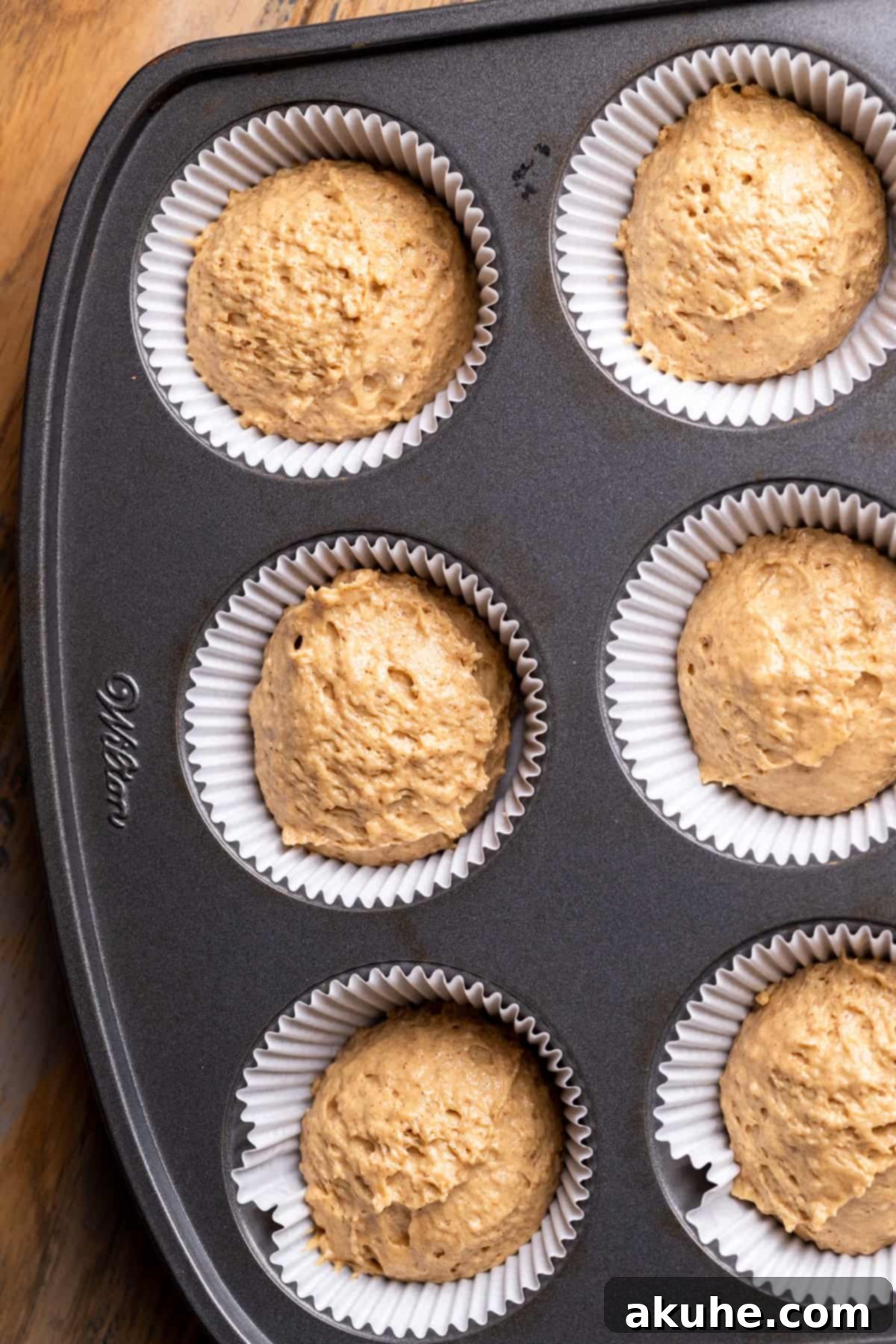 Cupcake batter precisely scooped into a cupcake pan.
