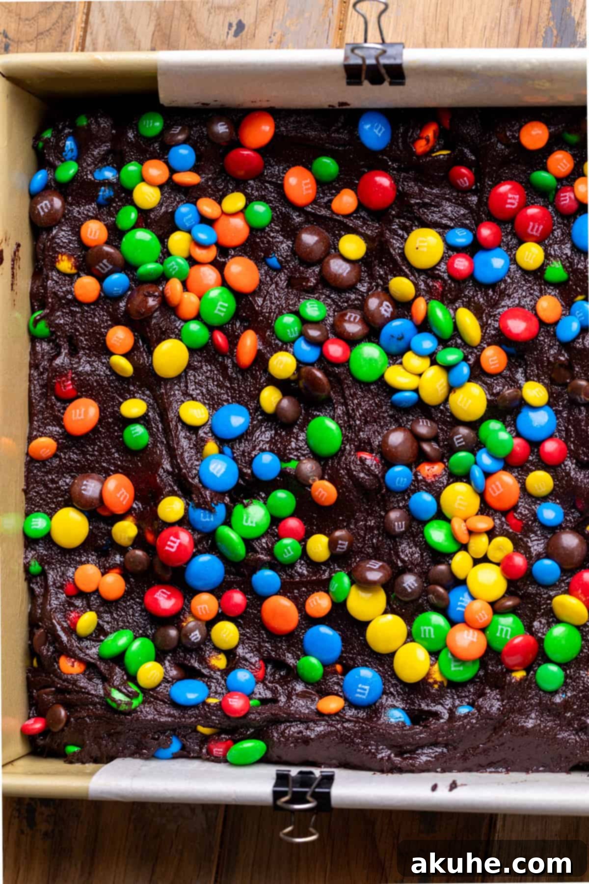 Decadent Fudgy M and M Brownies 7 Thick, chocolatey brownie batter spread evenly in a square baking pan, ready for the oven.