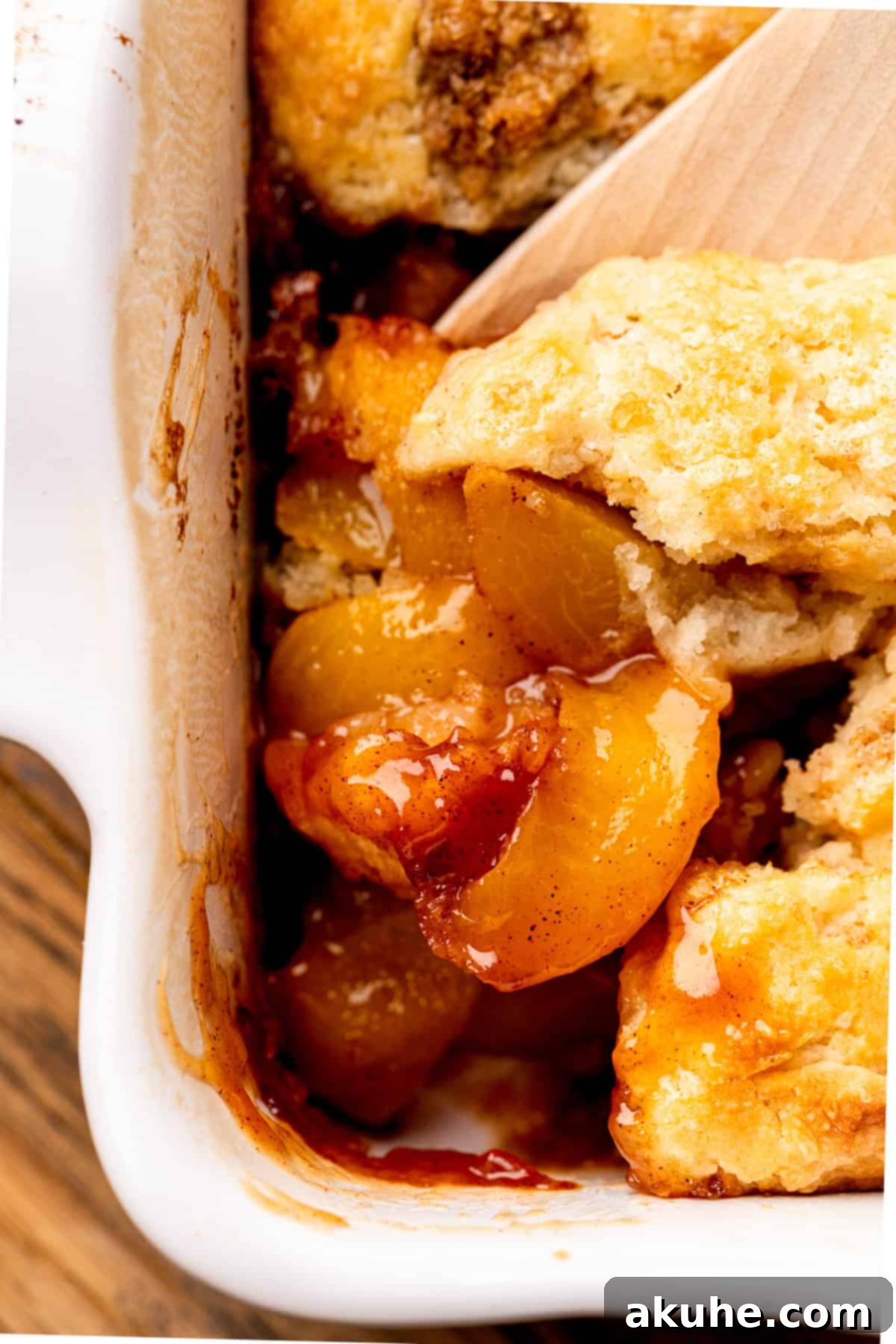 Close up of a spoonful of tender peach filling with cinnamon crumble.