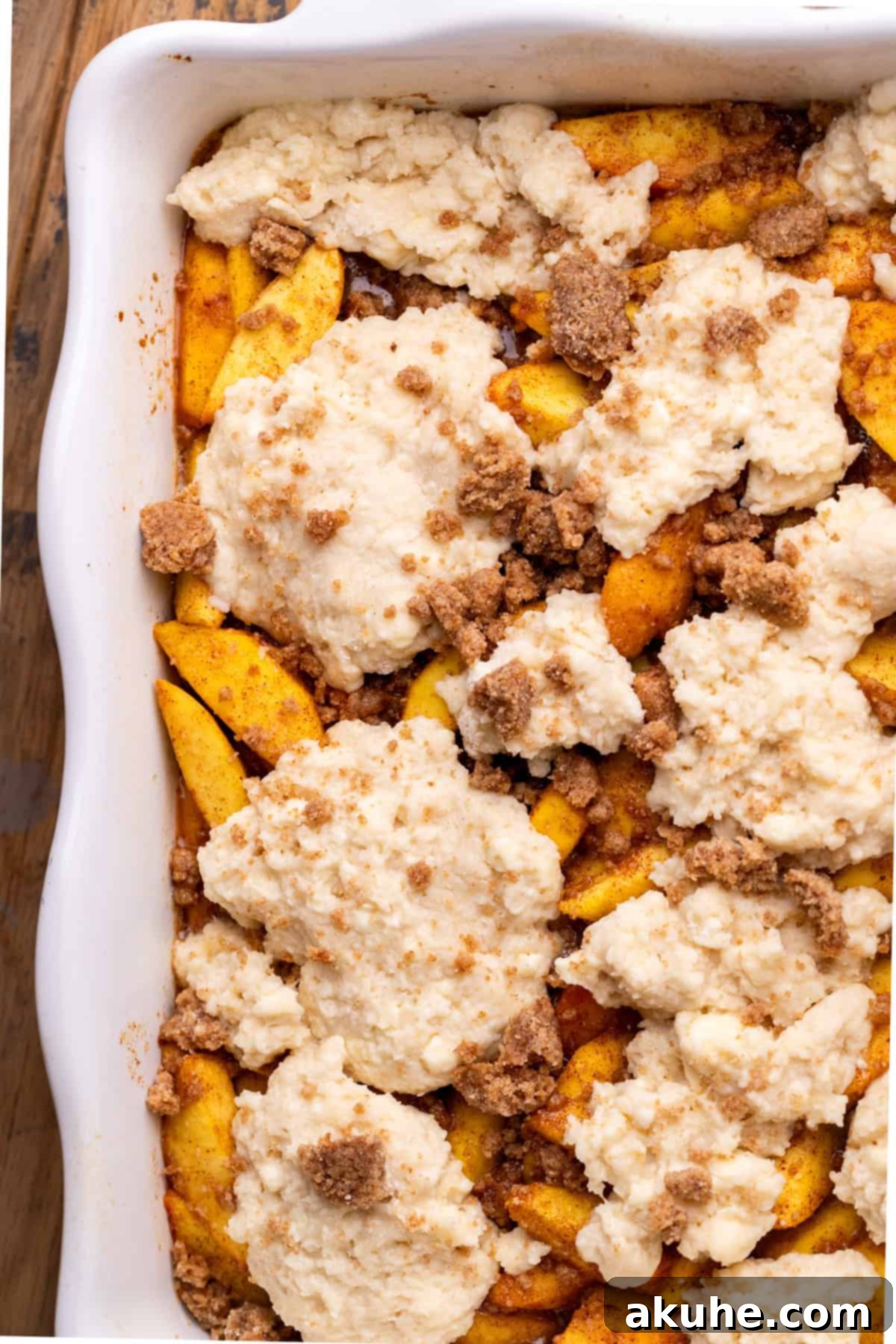 Dollops of biscuit dough placed on top of the peach filling in a casserole dish.