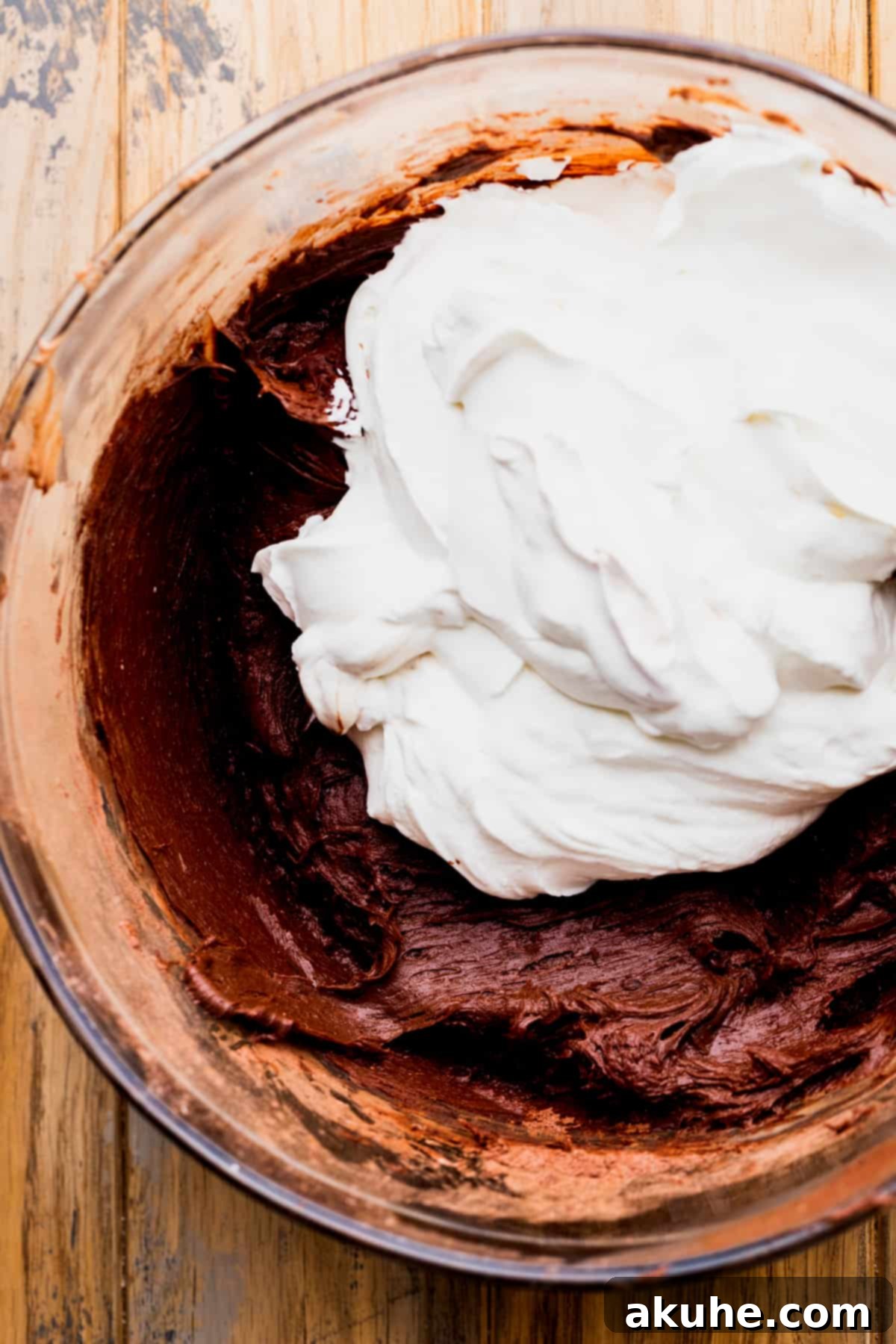 Whipped cream sitting on top of the Nutella cream cheese mixture before folding.