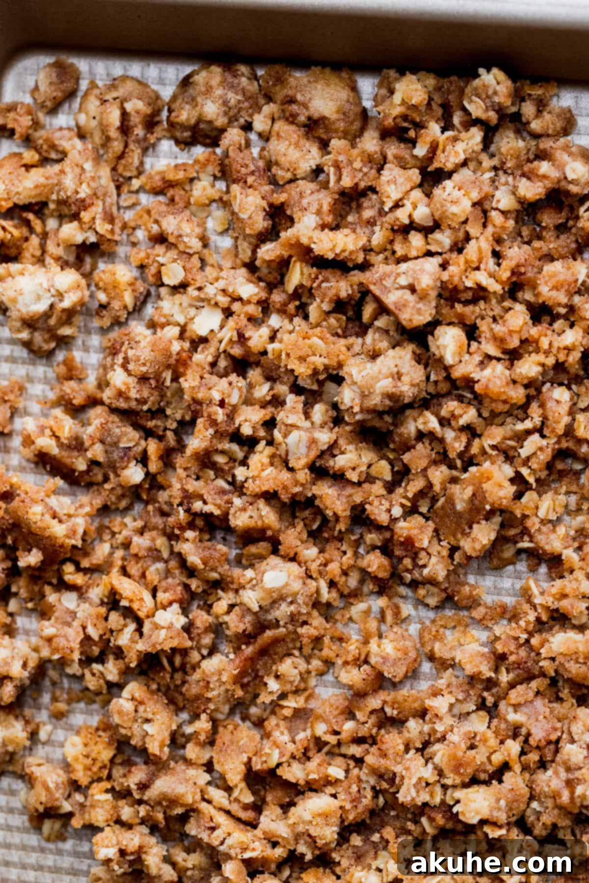 Golden brown, cooked oat crumble on a cookie sheet, ready to be broken up.