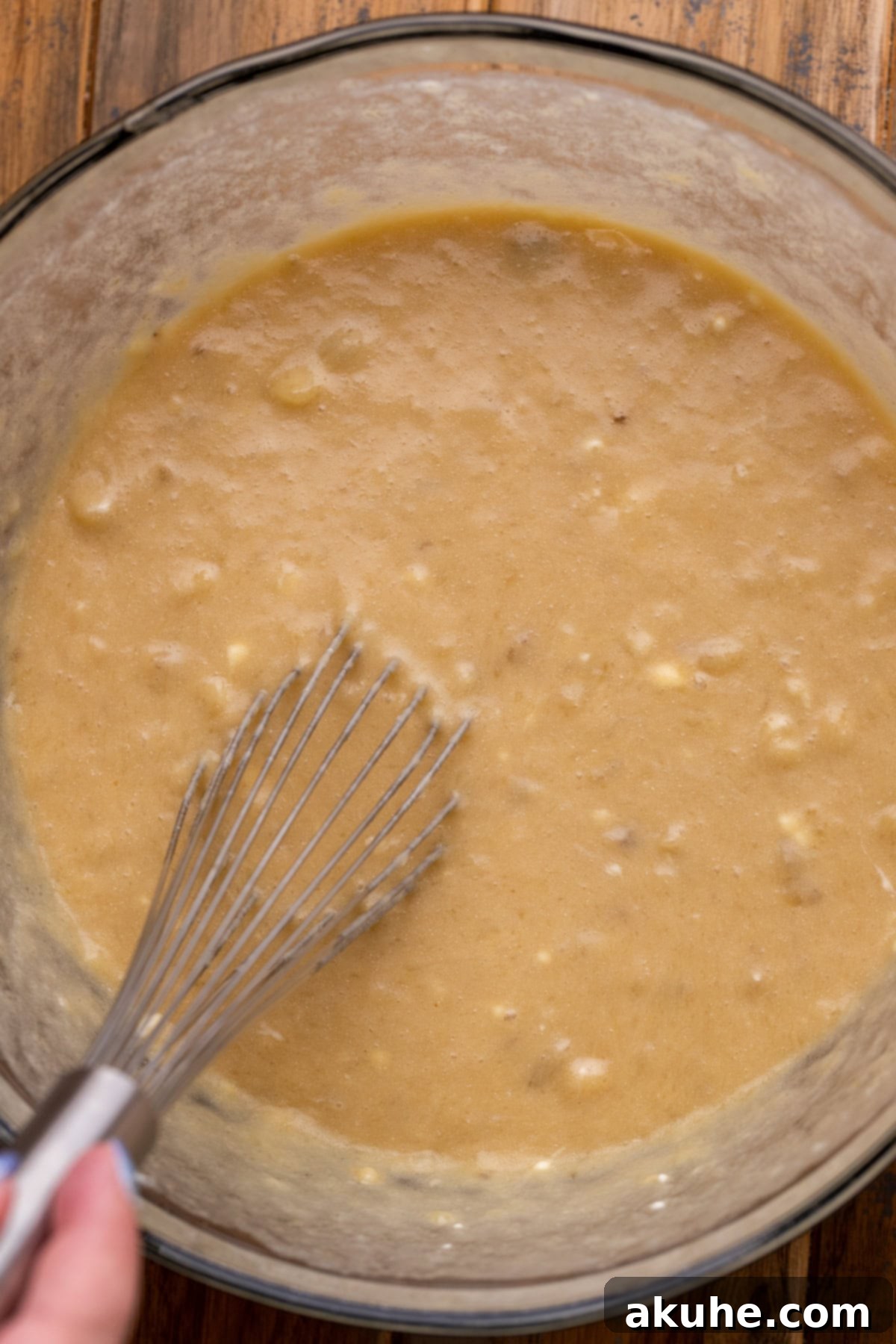 Decadent Banana Chocolate Dream Cake 4 Wet ingredients for banana cake in a clear glass bowl, showcasing their smooth consistency.