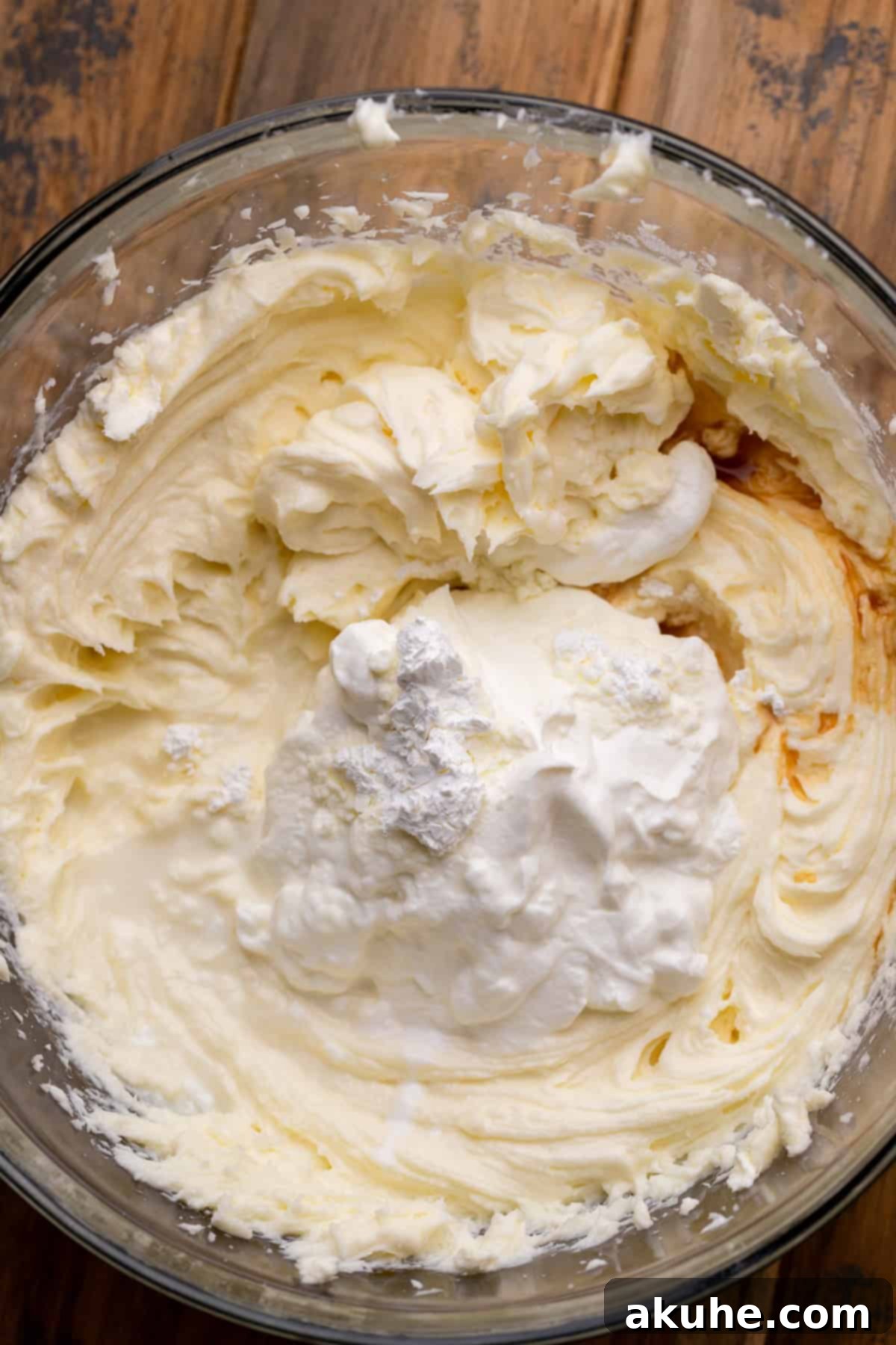 Wet ingredients for cheesecake batter in a mixing bowl.