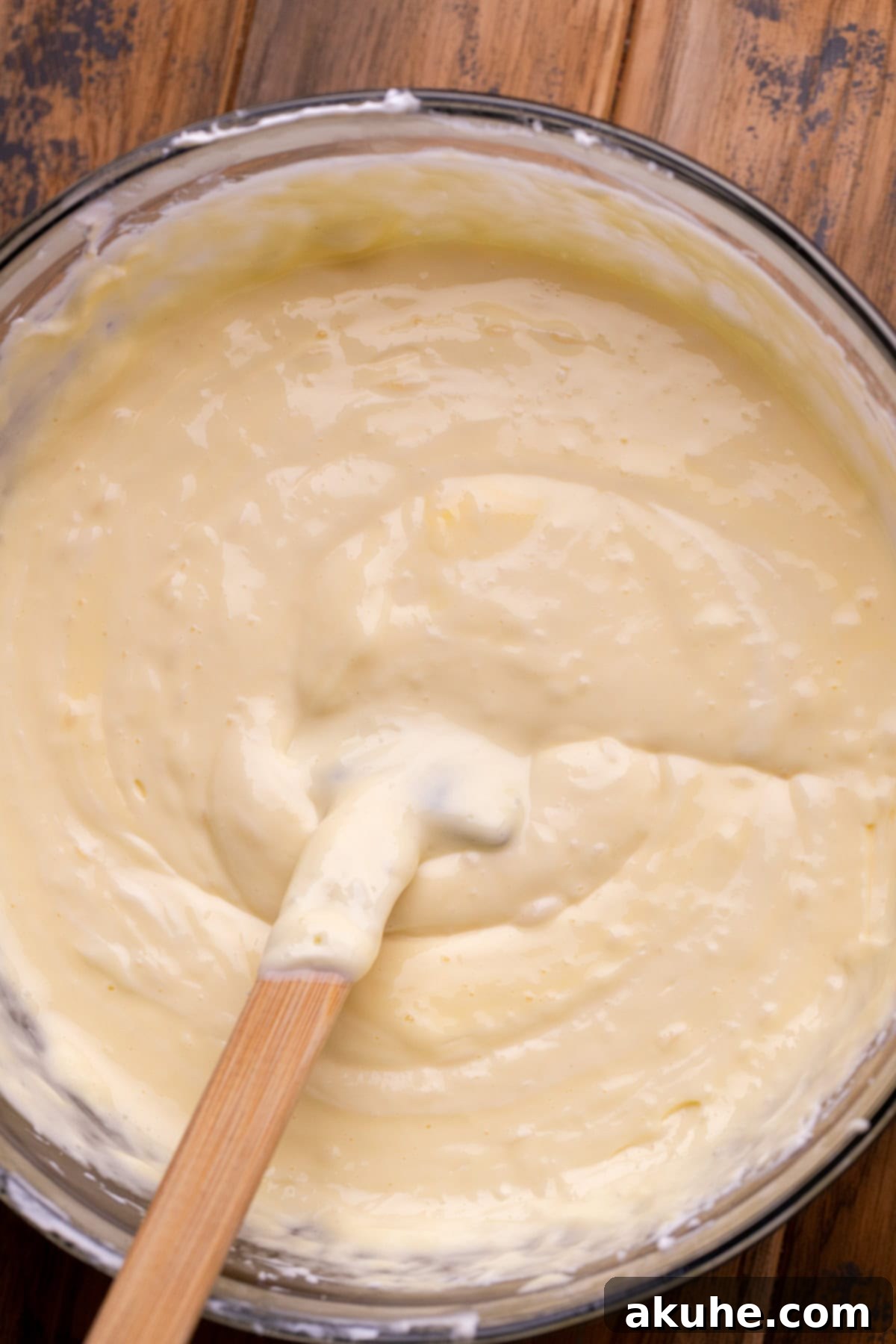 Smooth, creamy cheesecake batter in a large glass bowl.
