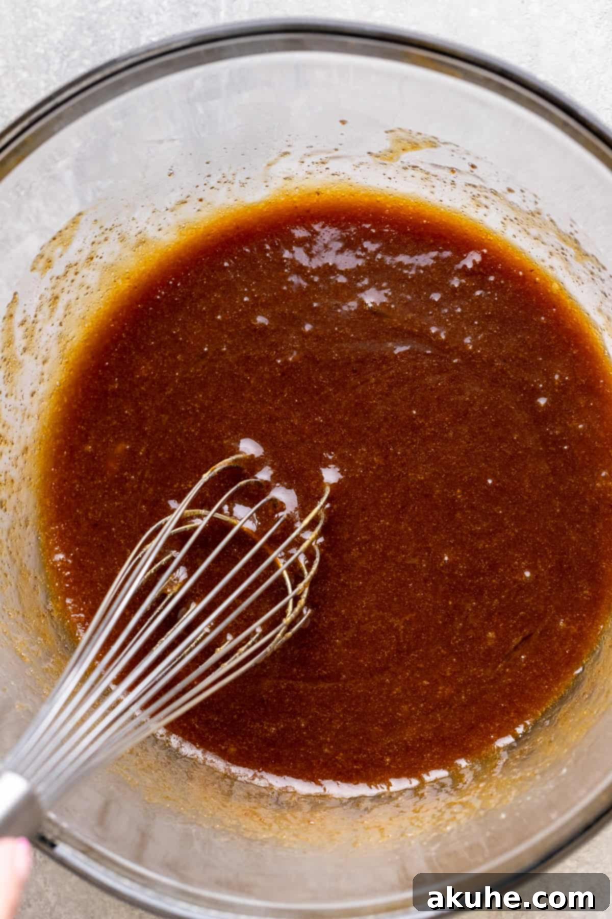 Decadent Caramel Cookie Bars 5 Wet ingredients for the cookie dough, perfectly mixed in a clear glass bowl.