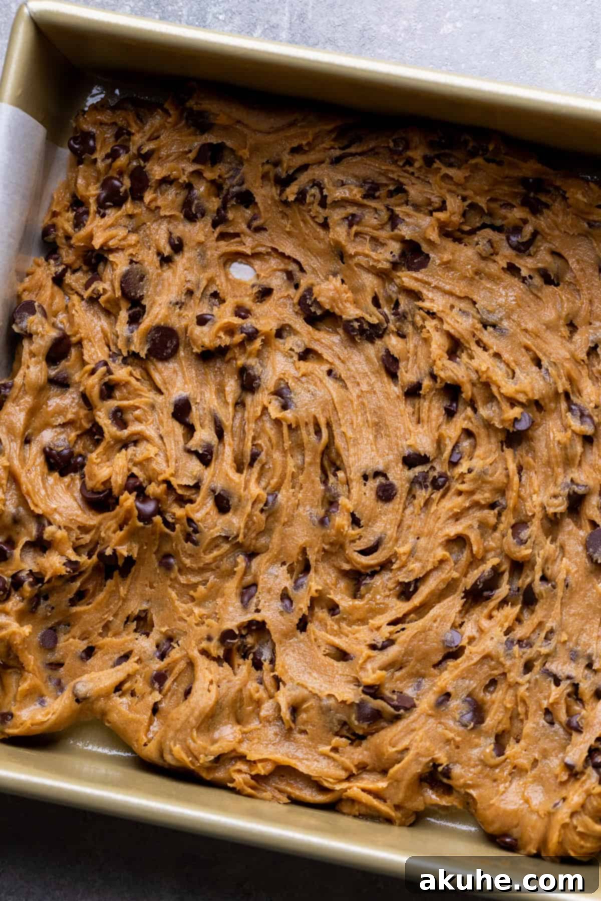 Decadent Caramel Cookie Bars 7 A foundational layer of cookie dough spread evenly across a baking pan.