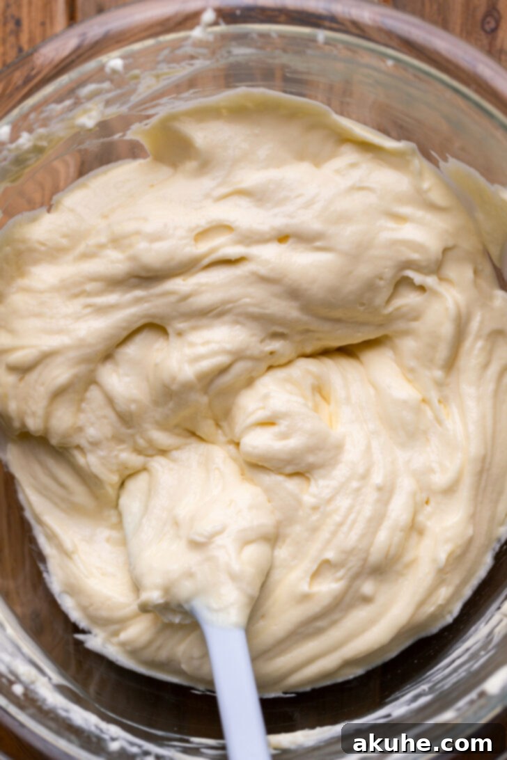 Autumn Pumpkin Streusel Cake 5 Cream cheese batter in a bowl, showing its smooth texture.