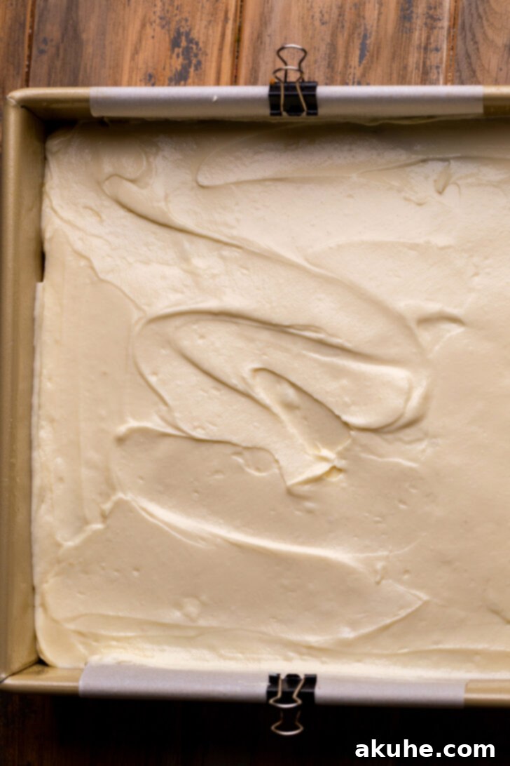 Autumn Pumpkin Streusel Cake 8 Cream cheese batter dolloped over the pumpkin cake batter in the pan.