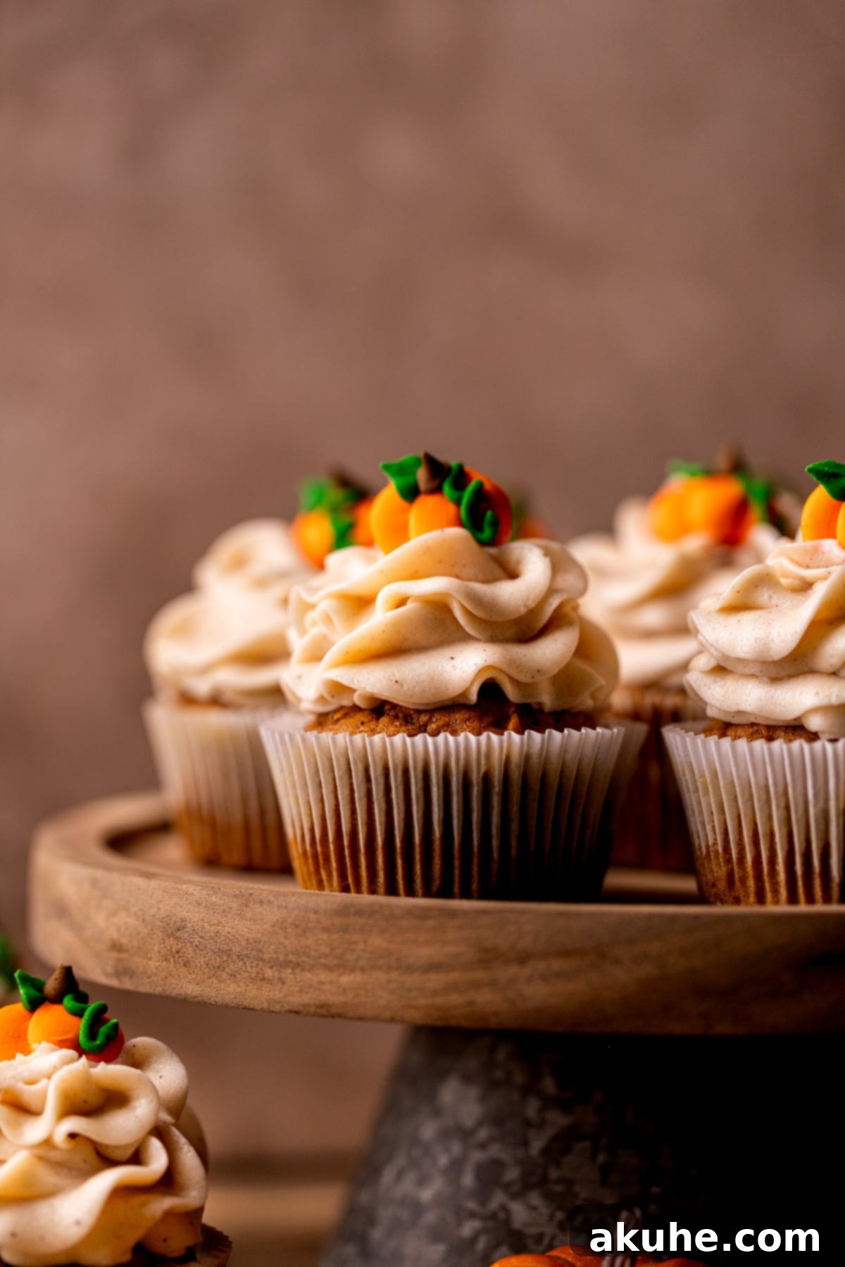 Autumn Pumpkin Spice Cupcakes 9 A close-up view of a perfectly frosted pumpkin cupcake, highlighting the swirls of cinnamon cream cheese frosting and the soft crumb.
