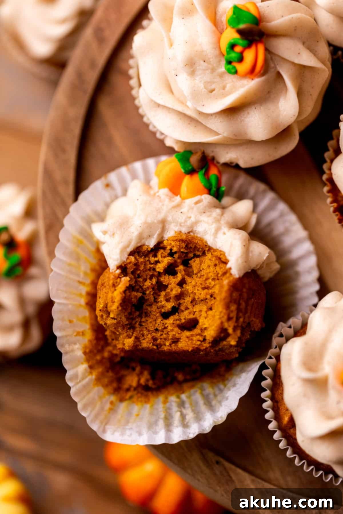 Autumn Pumpkin Spice Cupcakes 10 Top-down view of a pumpkin cupcake with a bite missing, showing the fluffy frosting and rich cake.