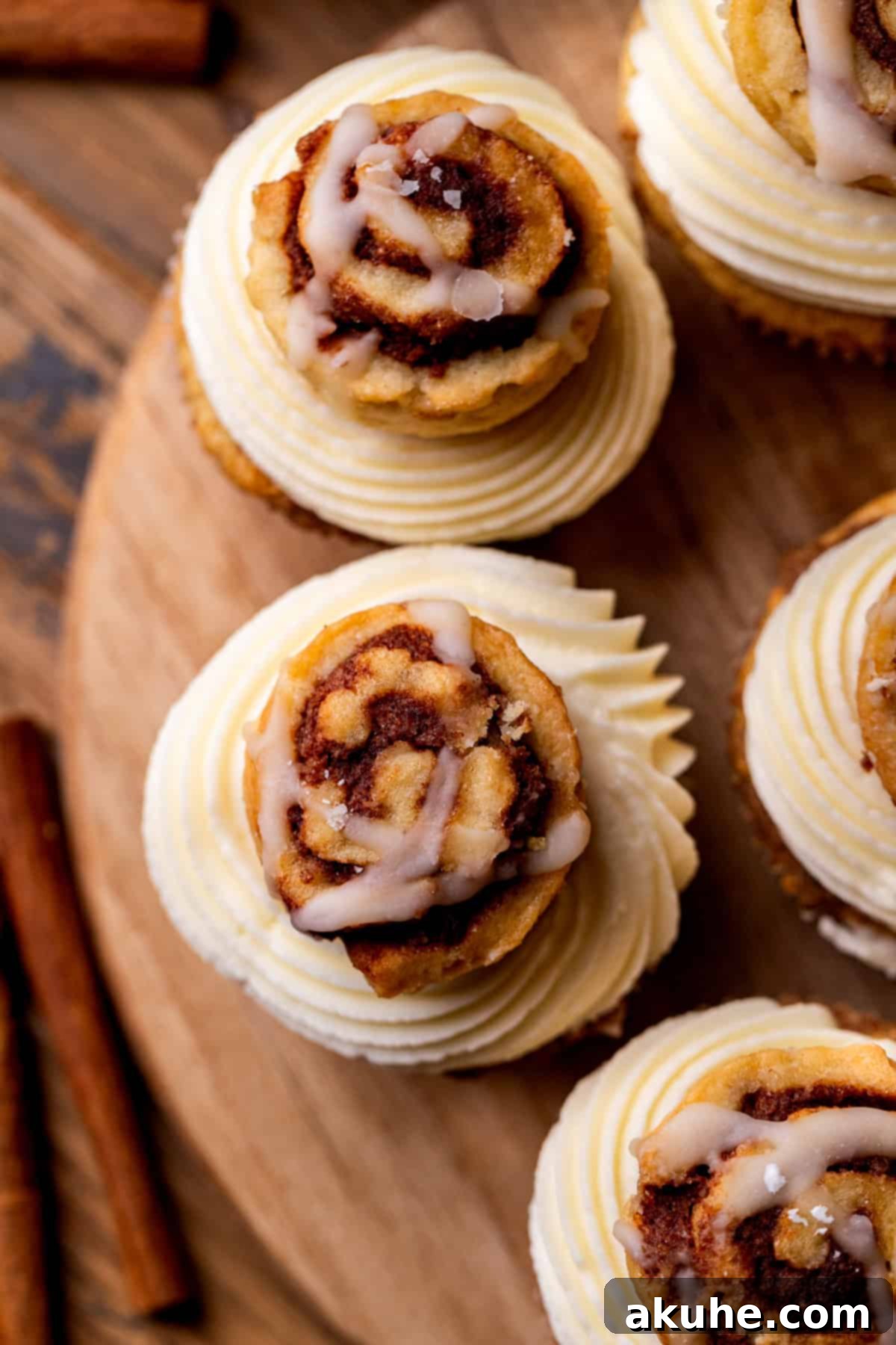 Top-down view of several frosted Cinnamon Roll Cupcakes, highlighting their detailed cream cheese icing and mini cinnamon roll toppings.