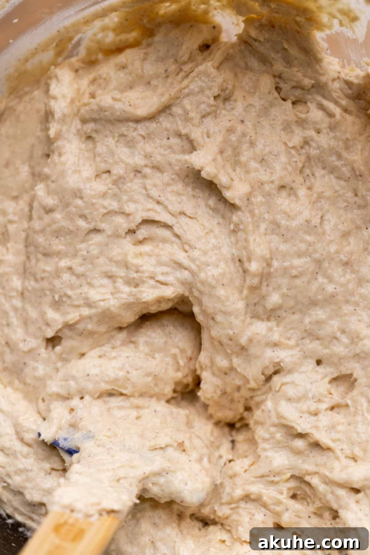 Smooth, spiced cinnamon cupcake batter in a clear glass bowl, ready for baking.