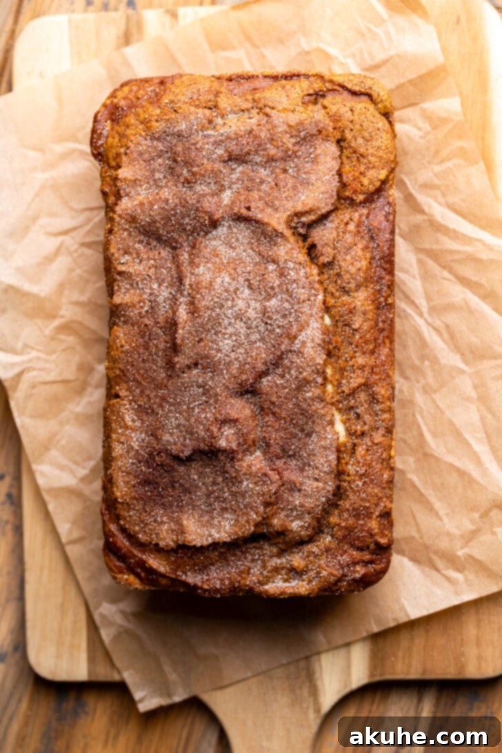 Cream Cheese Swirled Pumpkin Bread 8 Perfectly baked pumpkin cream cheese bread on a wooden cutting board.