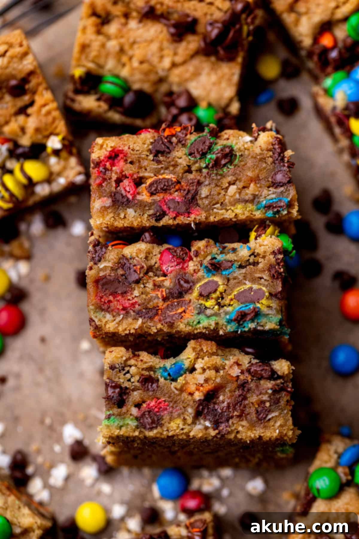 Ultimate Monster Cookie Bars 8 A top-down view of three perfectly arranged monster cookie bars, highlighting their colorful M&M's and chocolate chips.