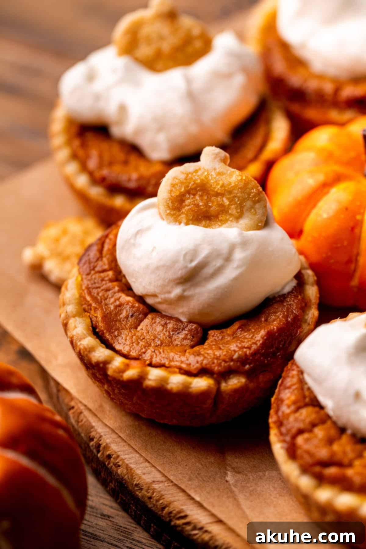 Side view of mini pumpkin pies arranged on a serving board.