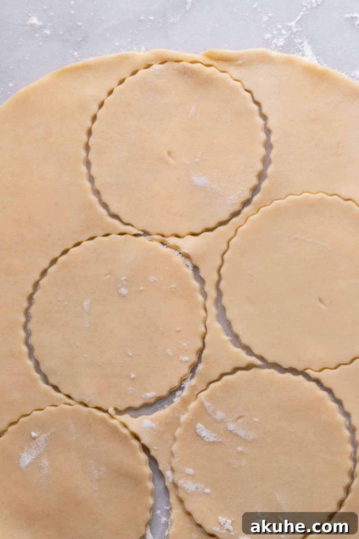 Pie dough with circles pressed in, ready for the muffin pan.