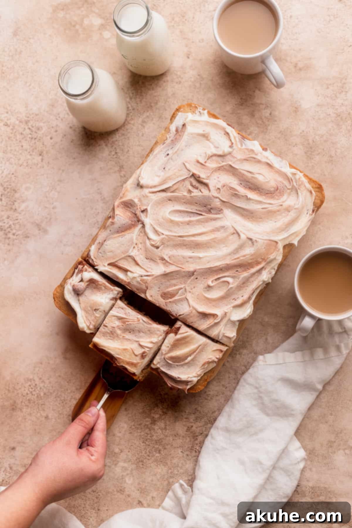 A delectable slice being carefully removed from a Chai Spiced Sheet Cake, showcasing its moist texture and rich chocolate swirl frosting.
