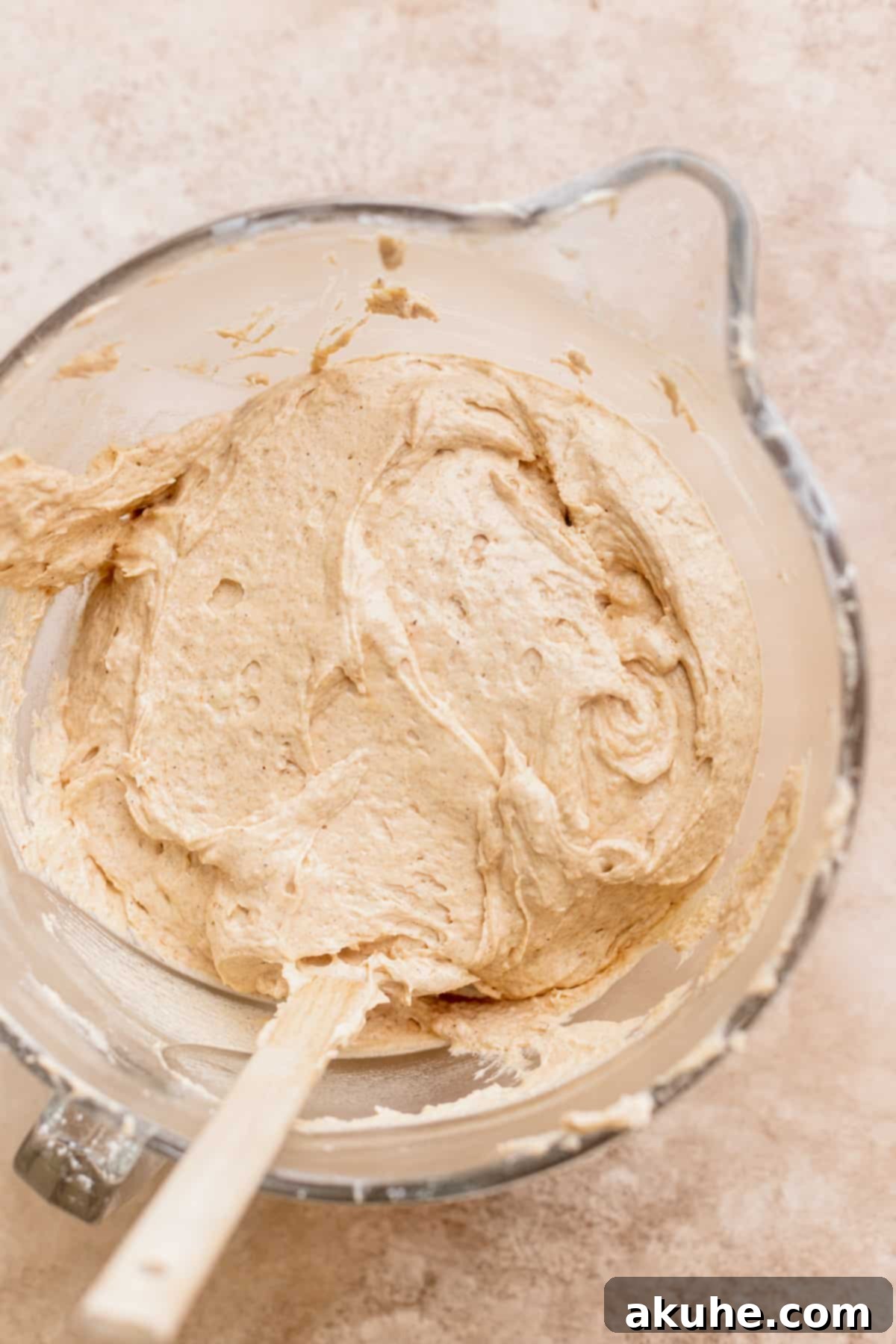 Smooth, golden cake batter resting in a clear glass bowl, glistening with promise.