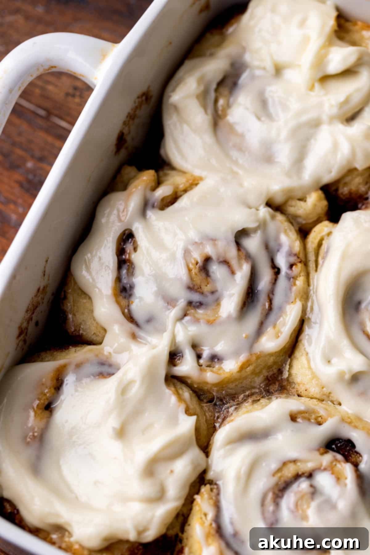 Close up of no yeast cinnamon rolls, showcasing their golden-brown edges and creamy white icing.
