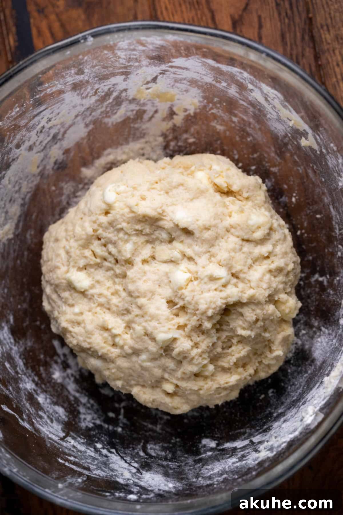 Smooth, well-kneaded dough resting in a glass bowl, ready for rolling.