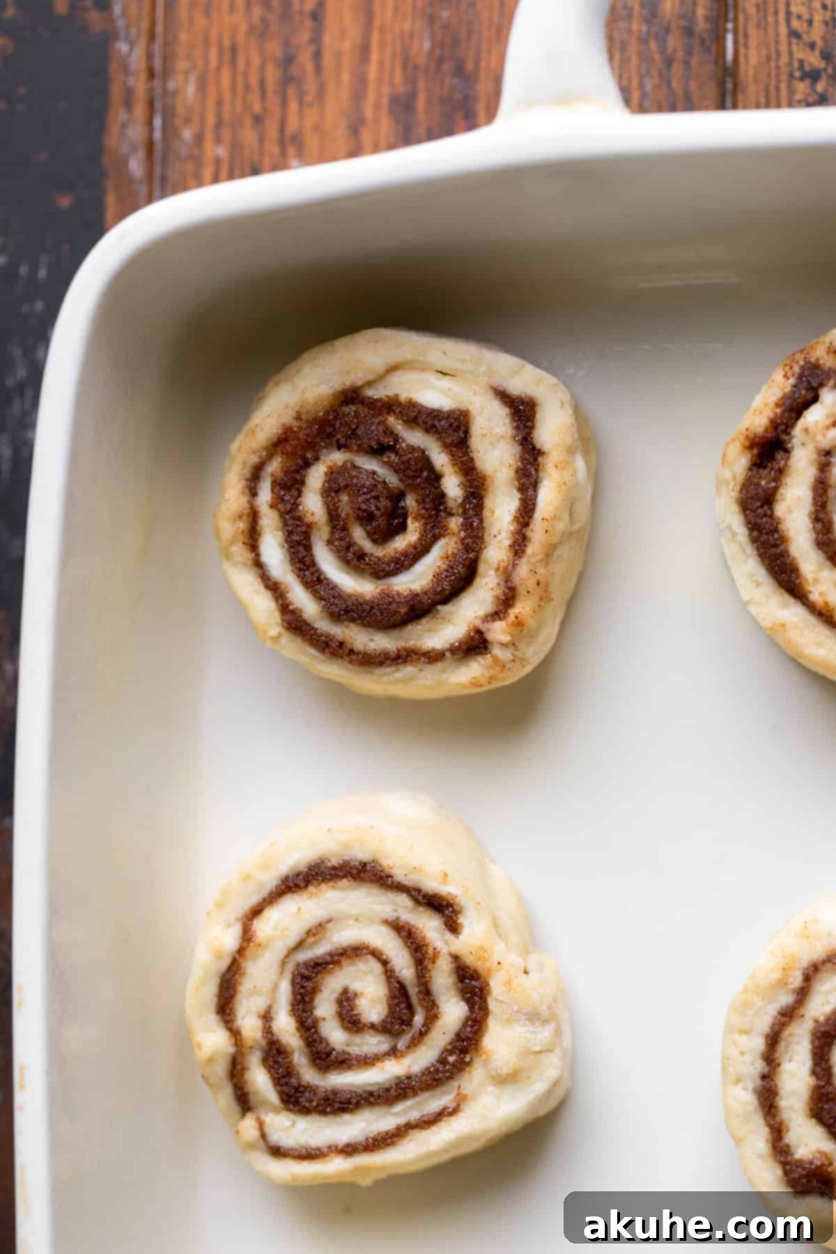 Freshly cut cinnamon rolls arranged neatly in a baking pan, ready for the oven.