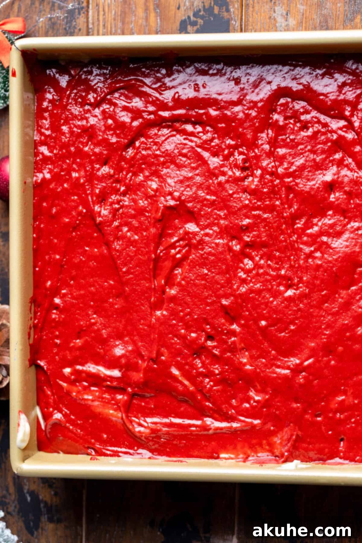 Festive Red Velvet Cake 7 Red velvet cake batter spread in the baking pan, ready for the cheesecake layer.