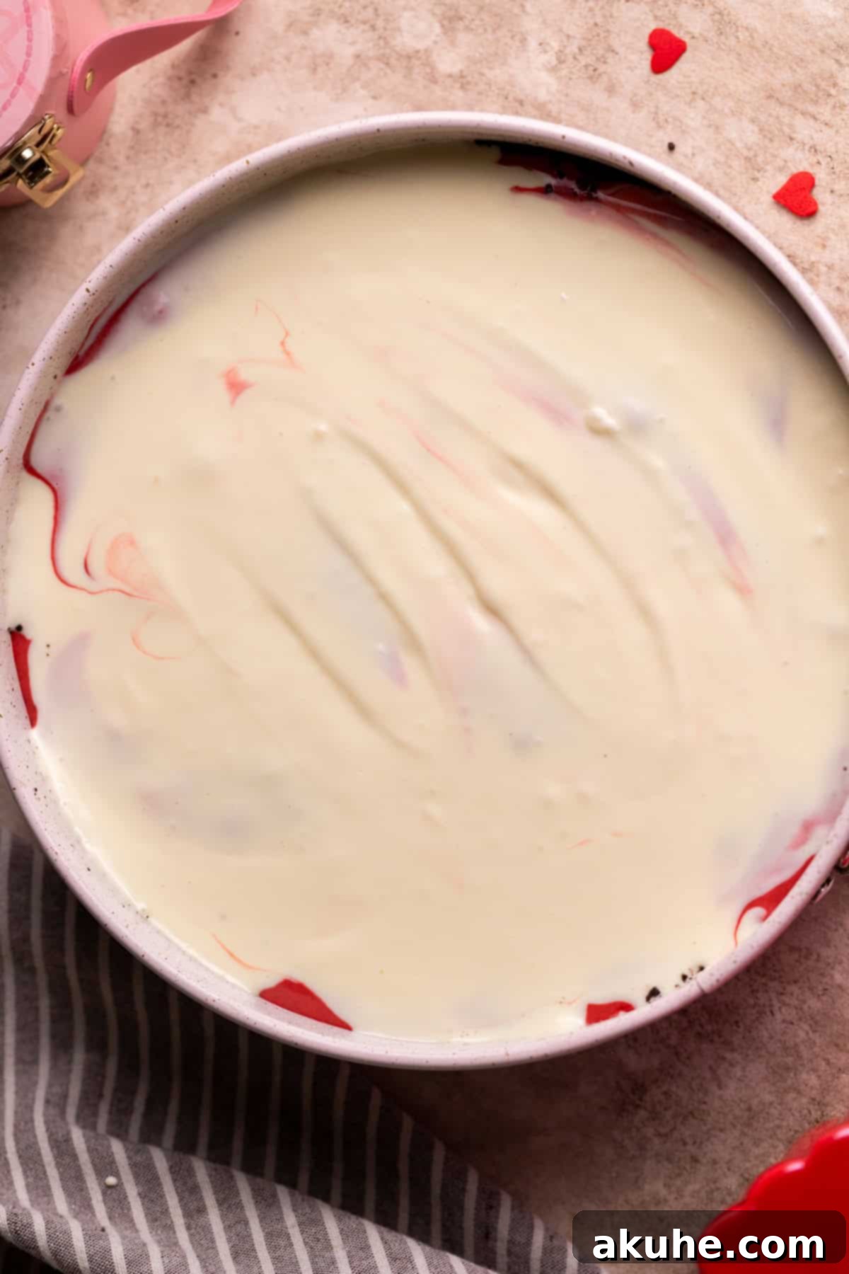 Red Velvet Decadence 8 Regular cheesecake batter dolloped on top of red velvet layer in the pan.