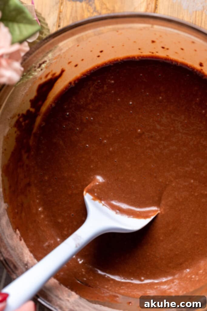 Raspberry Chocolate Cloud Cake 4 Chocolate cake batter in a glass bowl, showcasing its thin consistency.