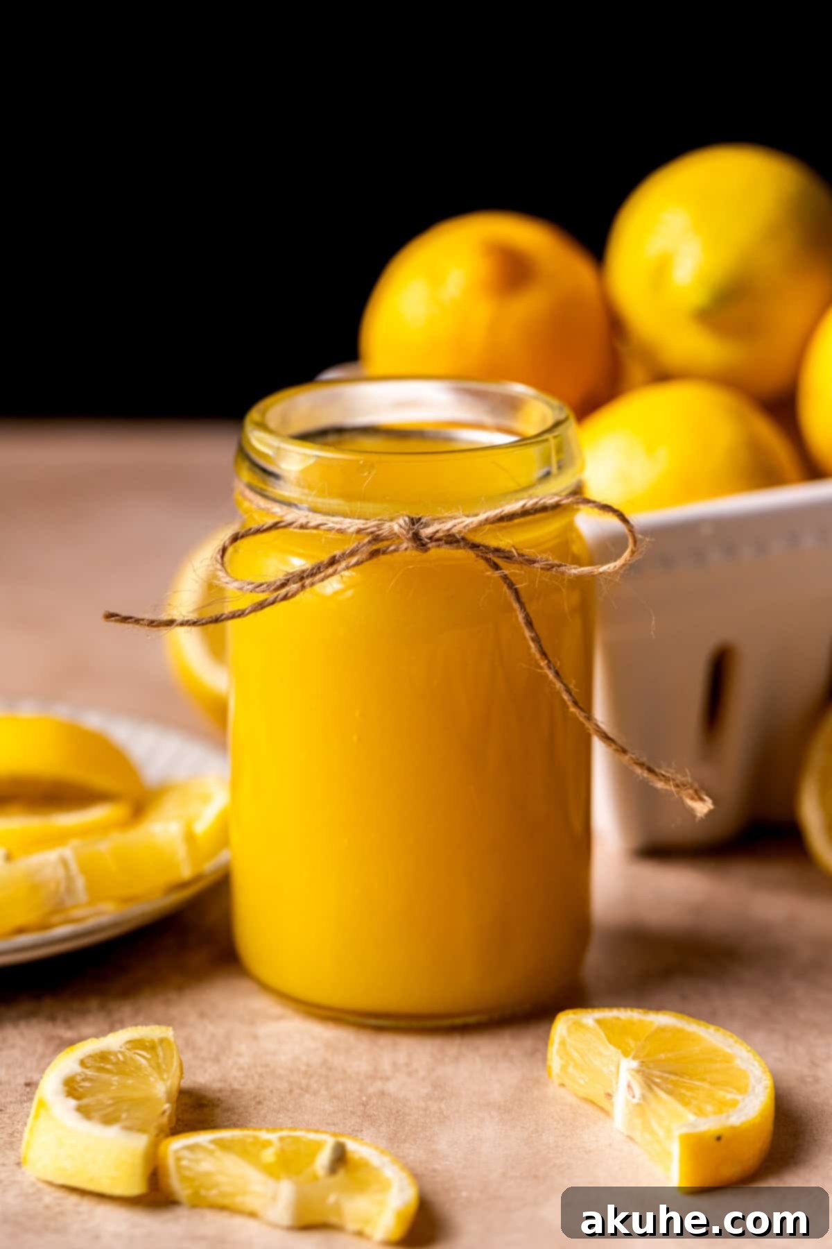 A beautifully presented jar of golden lemon curd, showcasing its smooth and inviting texture, ready to be enjoyed.