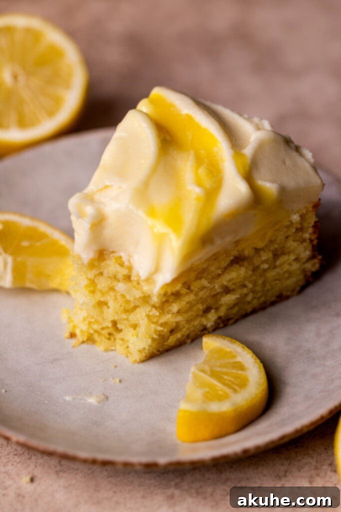 A close-up of a slice of lemon curd cake on a plate, ready to be enjoyed.