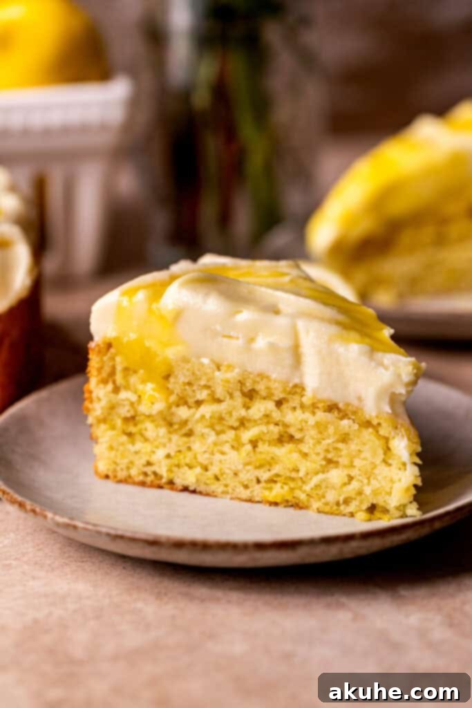 A perfectly portioned slice of lemon curd cake on a white plate, showcasing its layers.