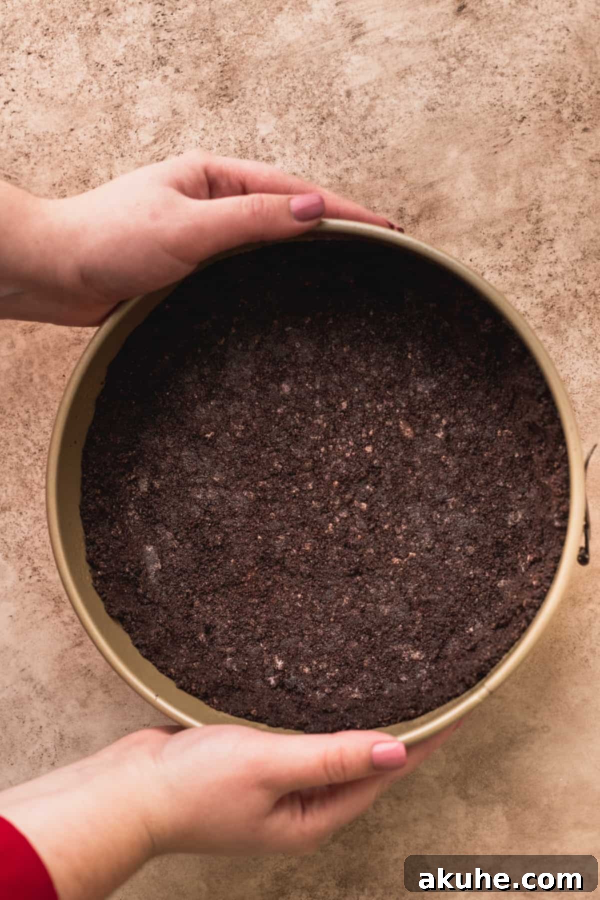 Decadent Triple Chocolate Cheesecake 4 Oreo crust pressed into a springform pan, ready for baking.